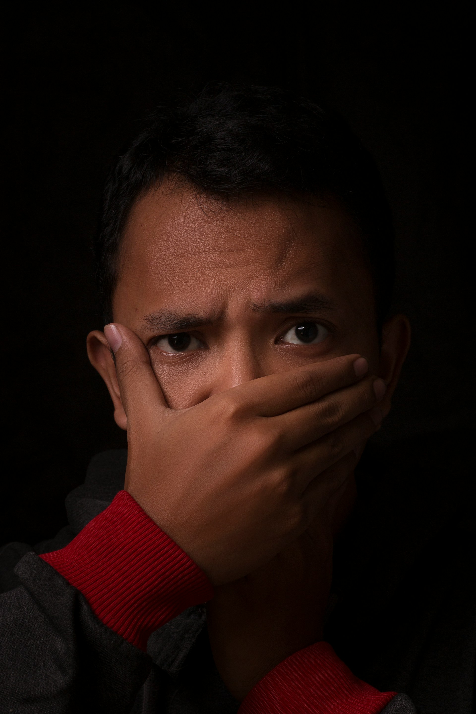 A man covering his mouth with one hand | Source: Unsplash