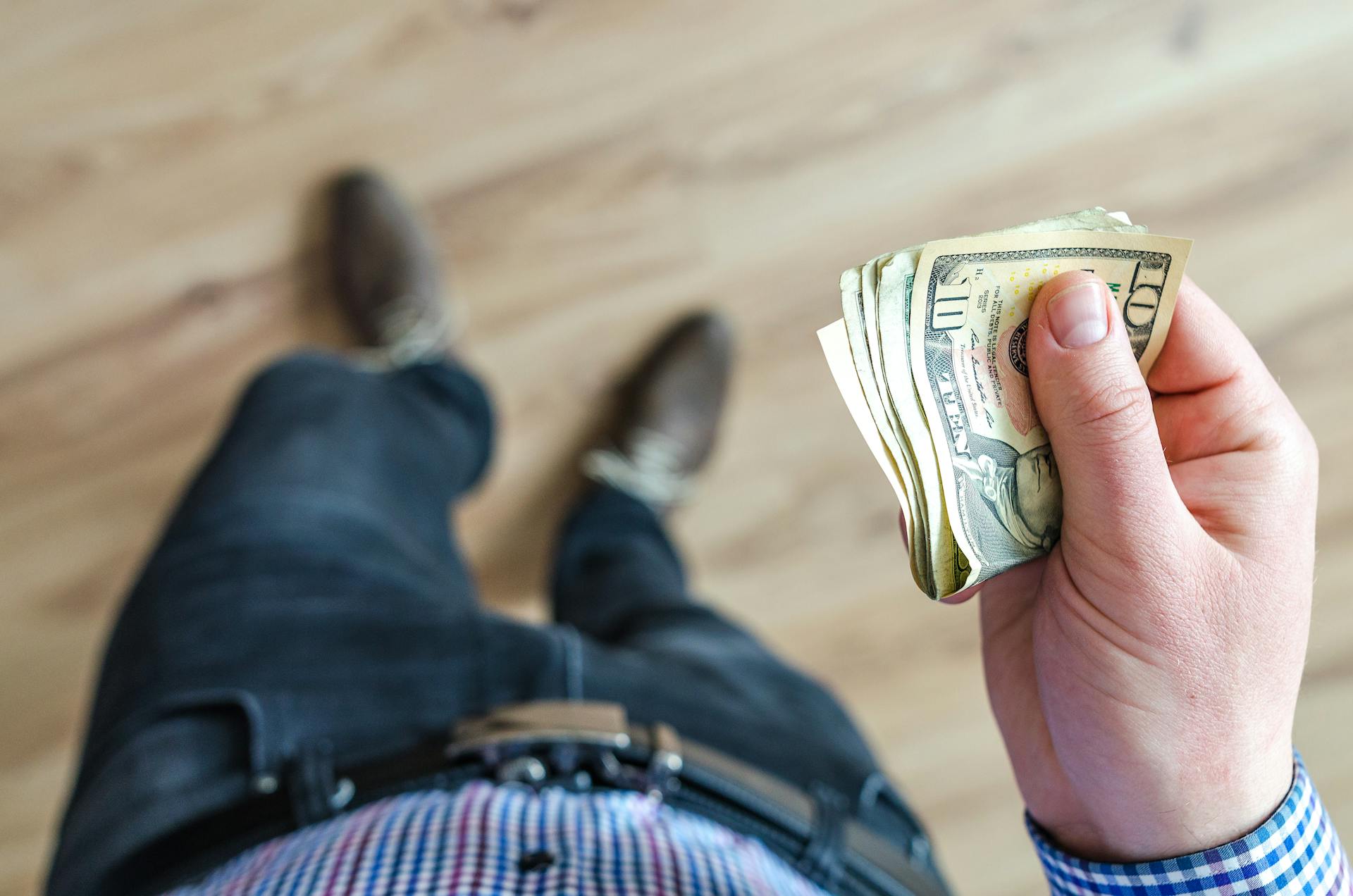 A man holding dollar bills | Source: Pexels
