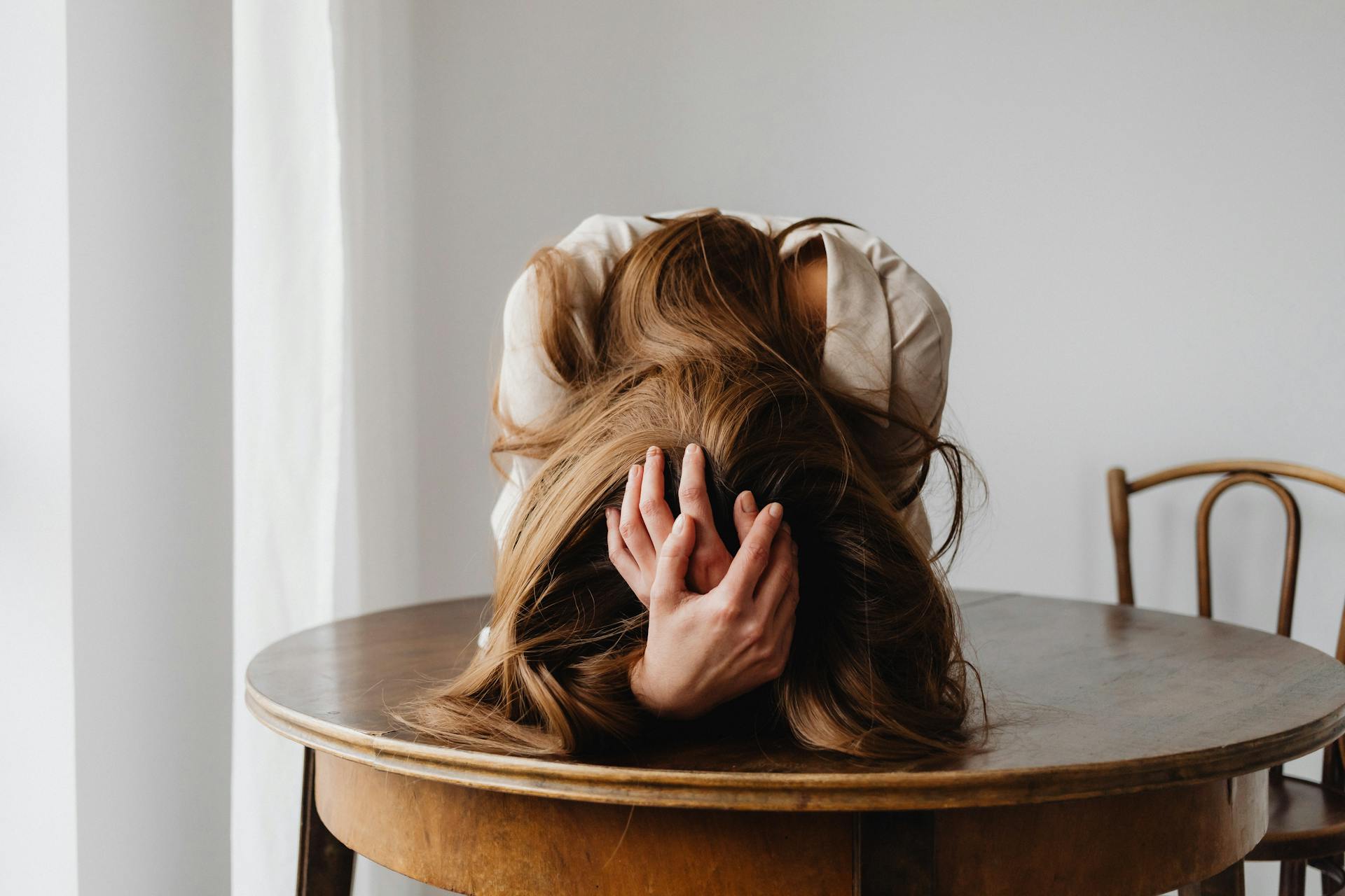 A woman holding her head in her hands | Source: Pexels