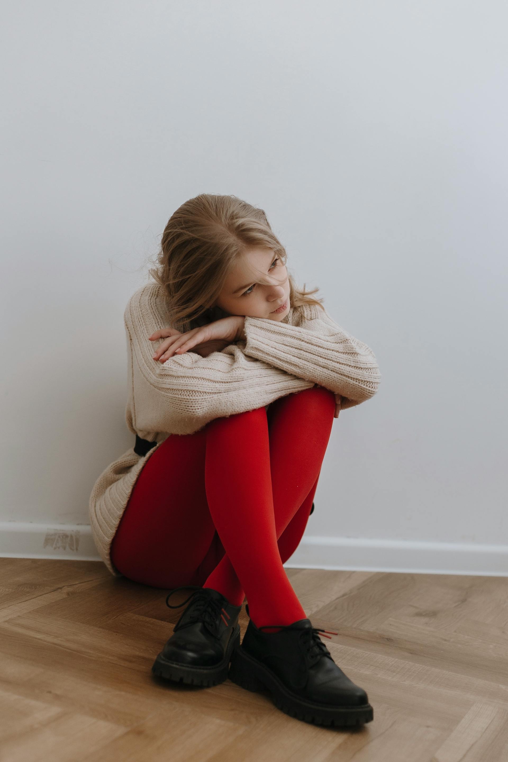 A tired woman sitting on the floor by the wall | Source: Pexels