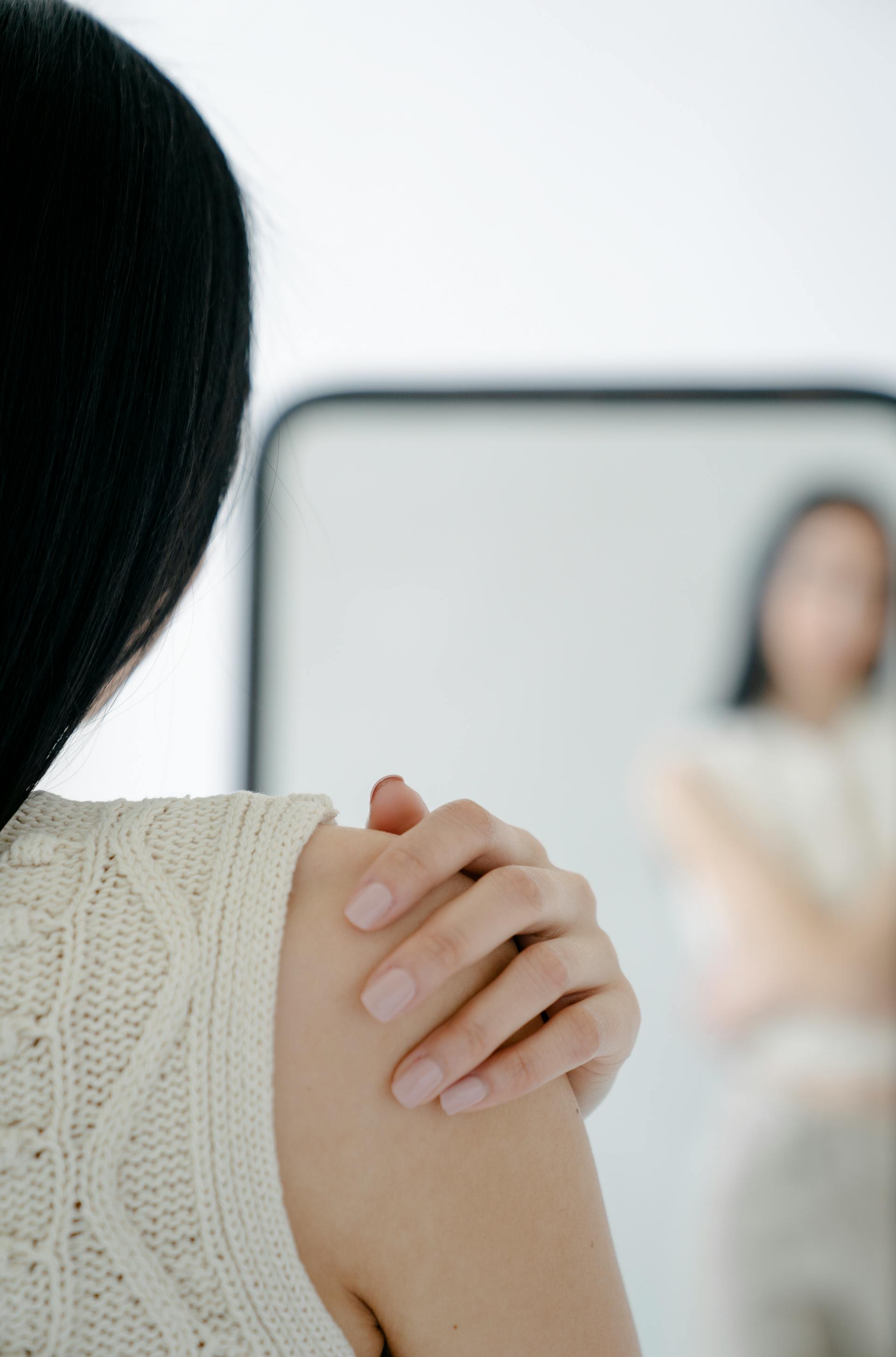 A woman staring into a mirror | Source: Pexels