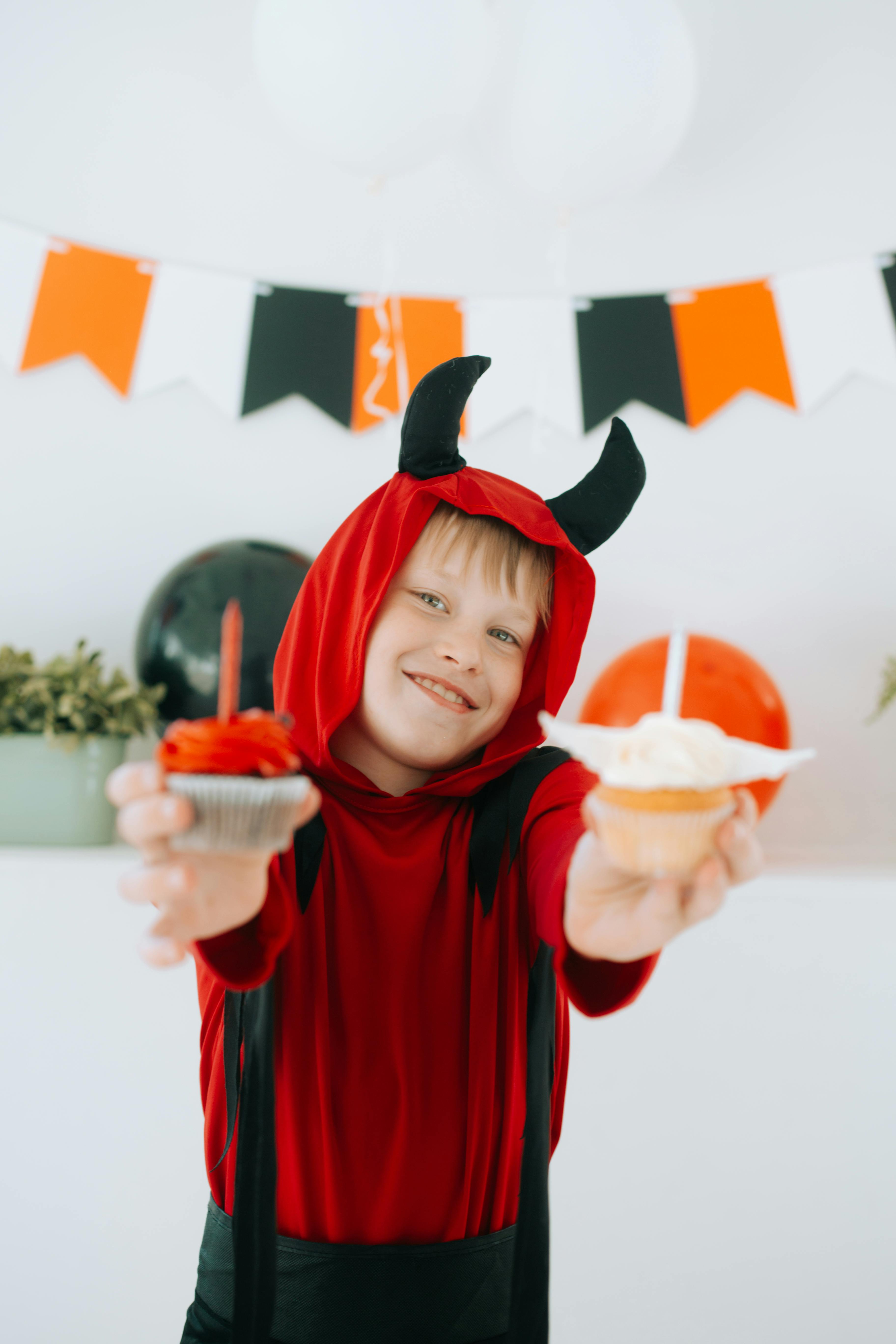 A little boy dressed for Halloween and holding treats | Source: Pexels
