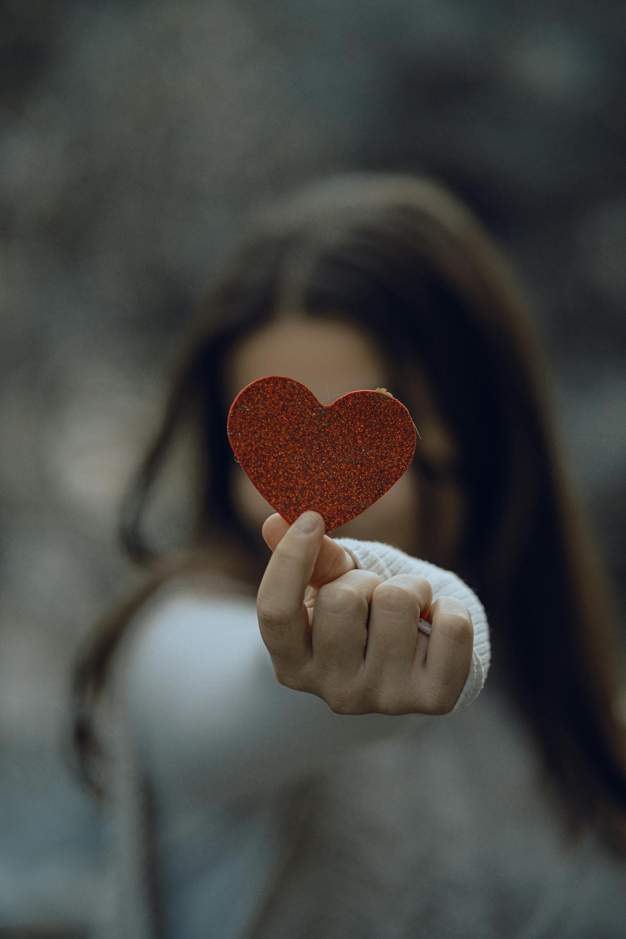My Sister Made Me Eat in the Garage at Her Wedding Because 'There Wasn't Enough Space for Everyone Inside' 1 A woman holding a glittery paper heart | Source: Pexels