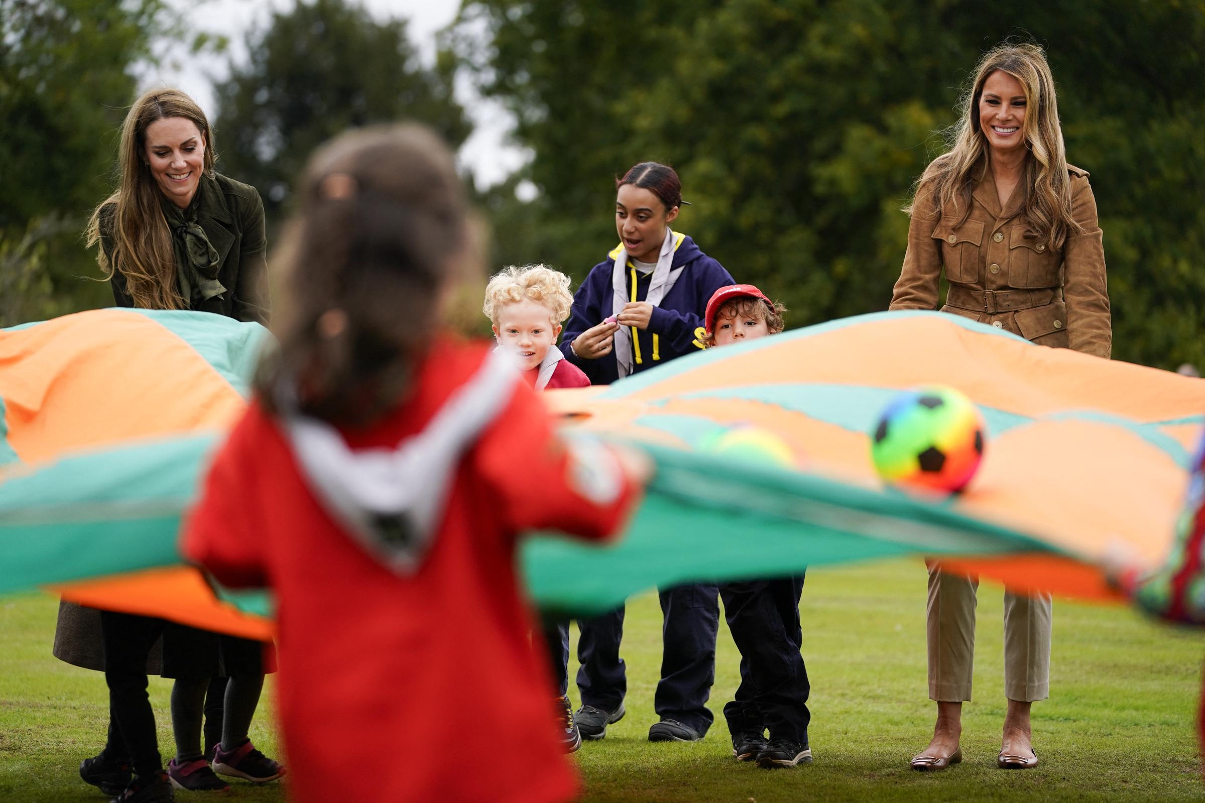 US First Lady Melania Trump and Catherine, Princess of Wales (L) shake a parachute filled with balls with a group of Squirrels from the Scout Association at Frogmore Cottage on the Windsor Estate, on September 18, 2025, during the second State Visit of US President Donald Trump. | Source: Getty Images