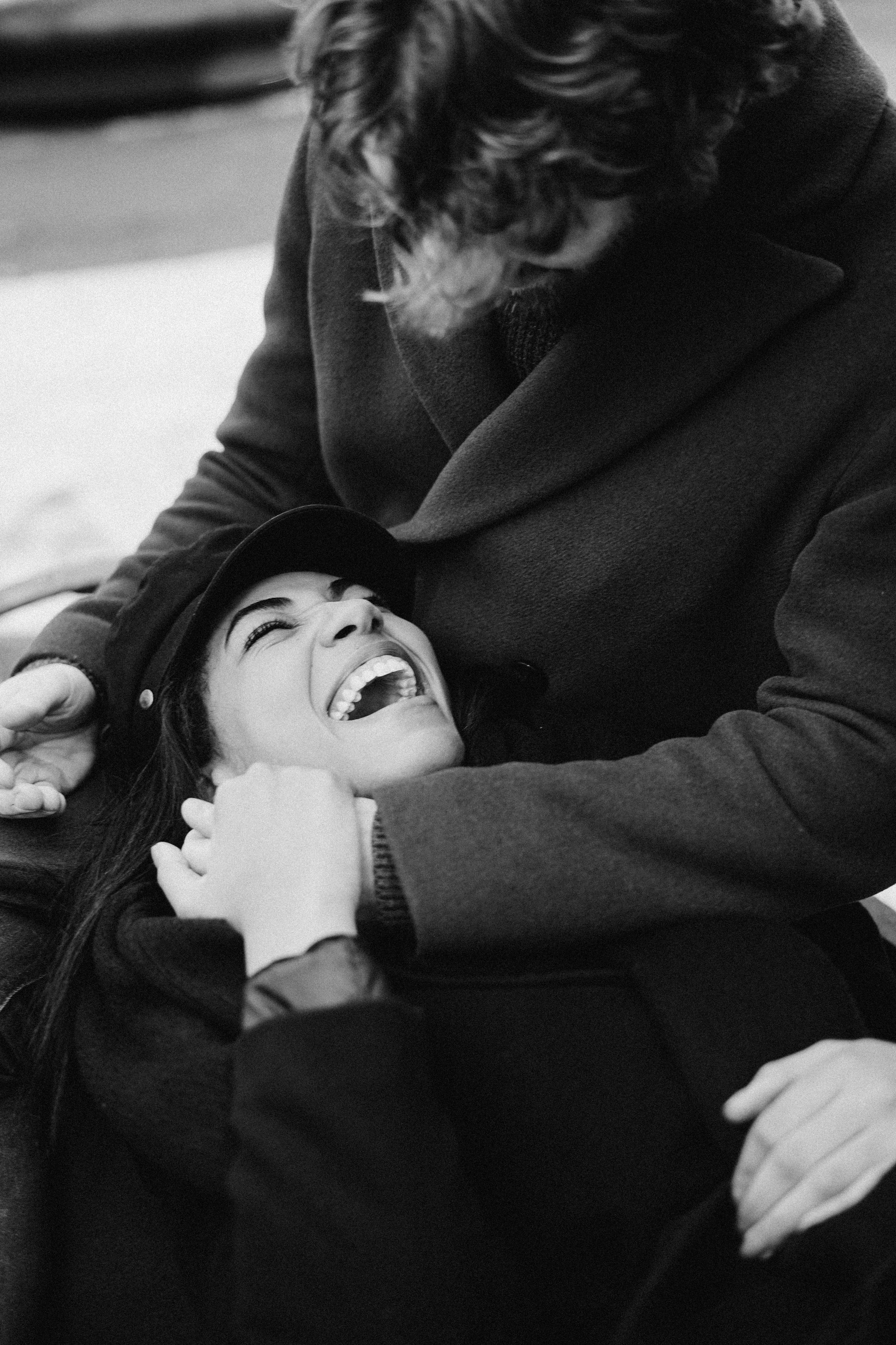A laughing woman in a man's embrace | Source: Pexels