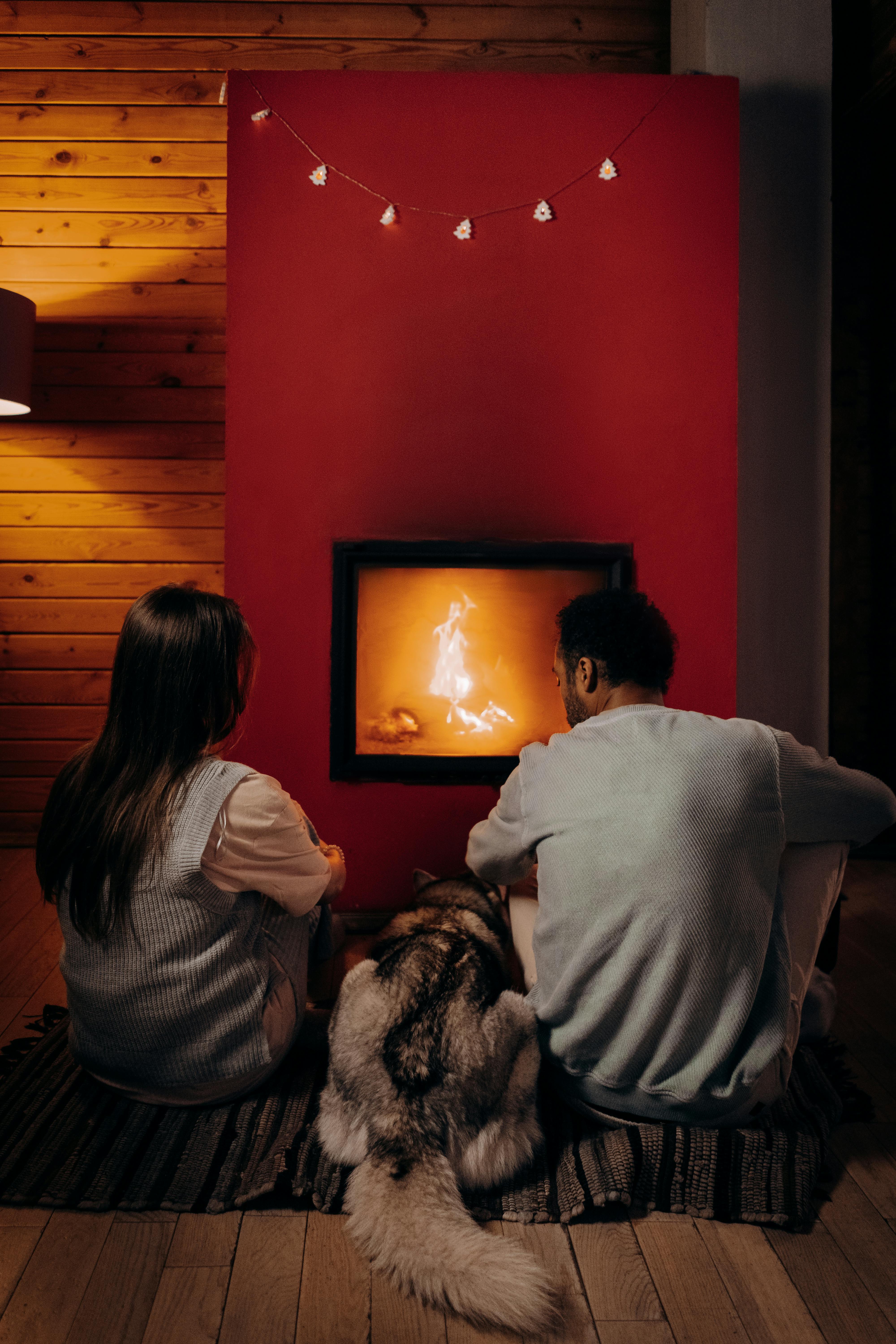 Couple sitting near a fire place with their dog | Source: Pexels