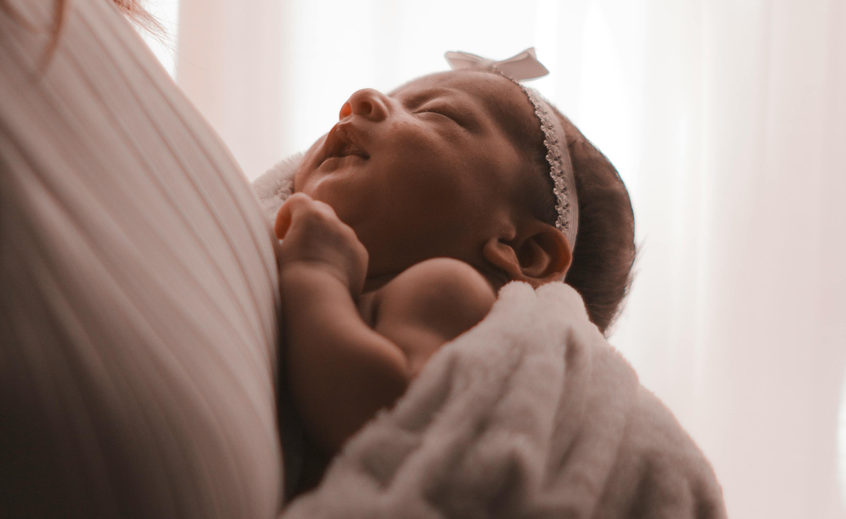 A mother holding a newborn baby | Source: Pexels