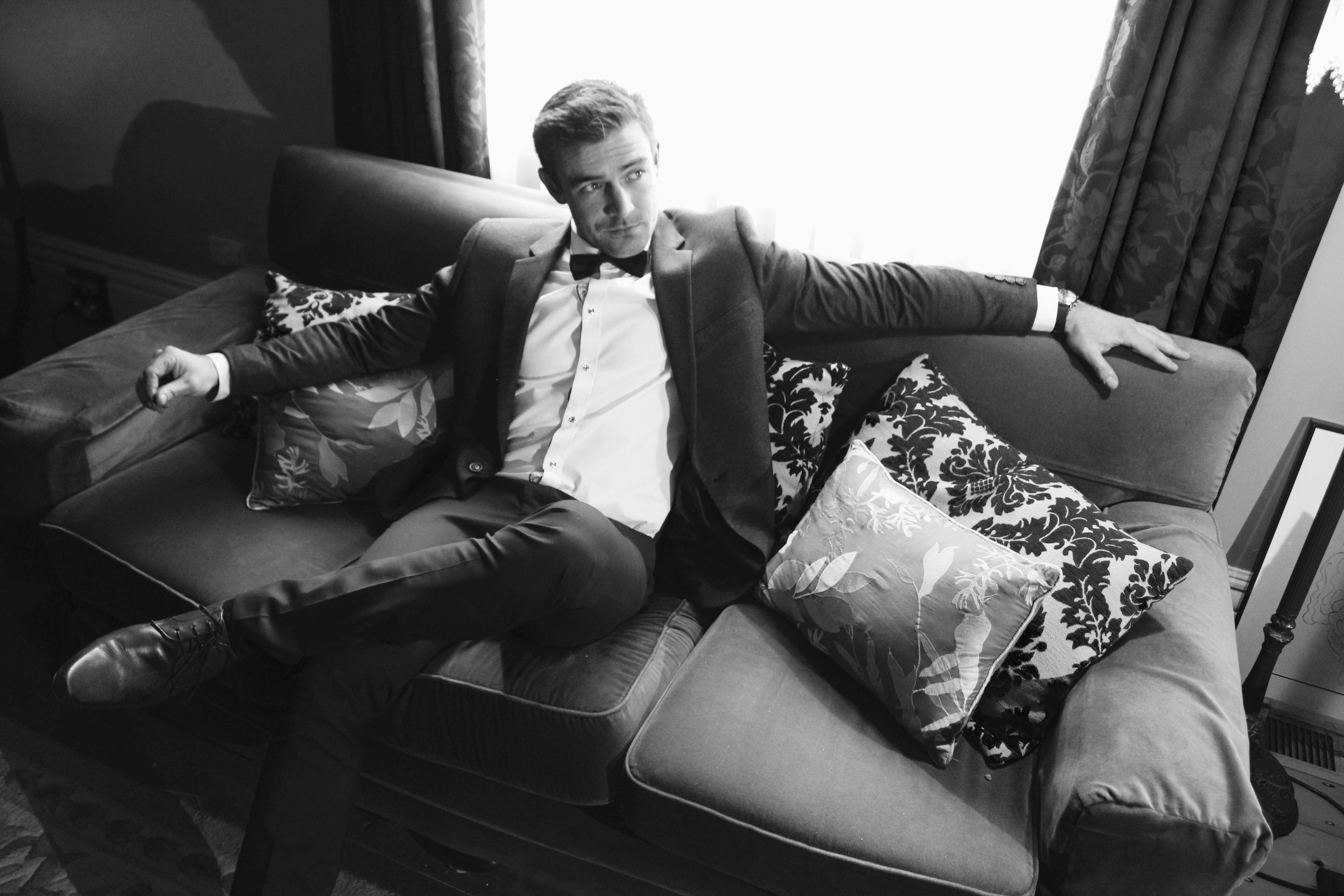 Man in a suit sitting on a sofa | Source: Pexels