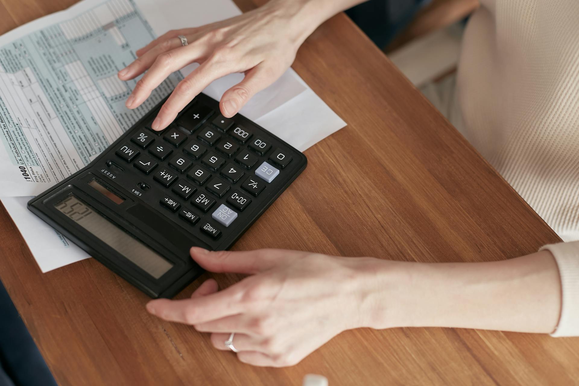 A woman using a calculator | Source: Pexels