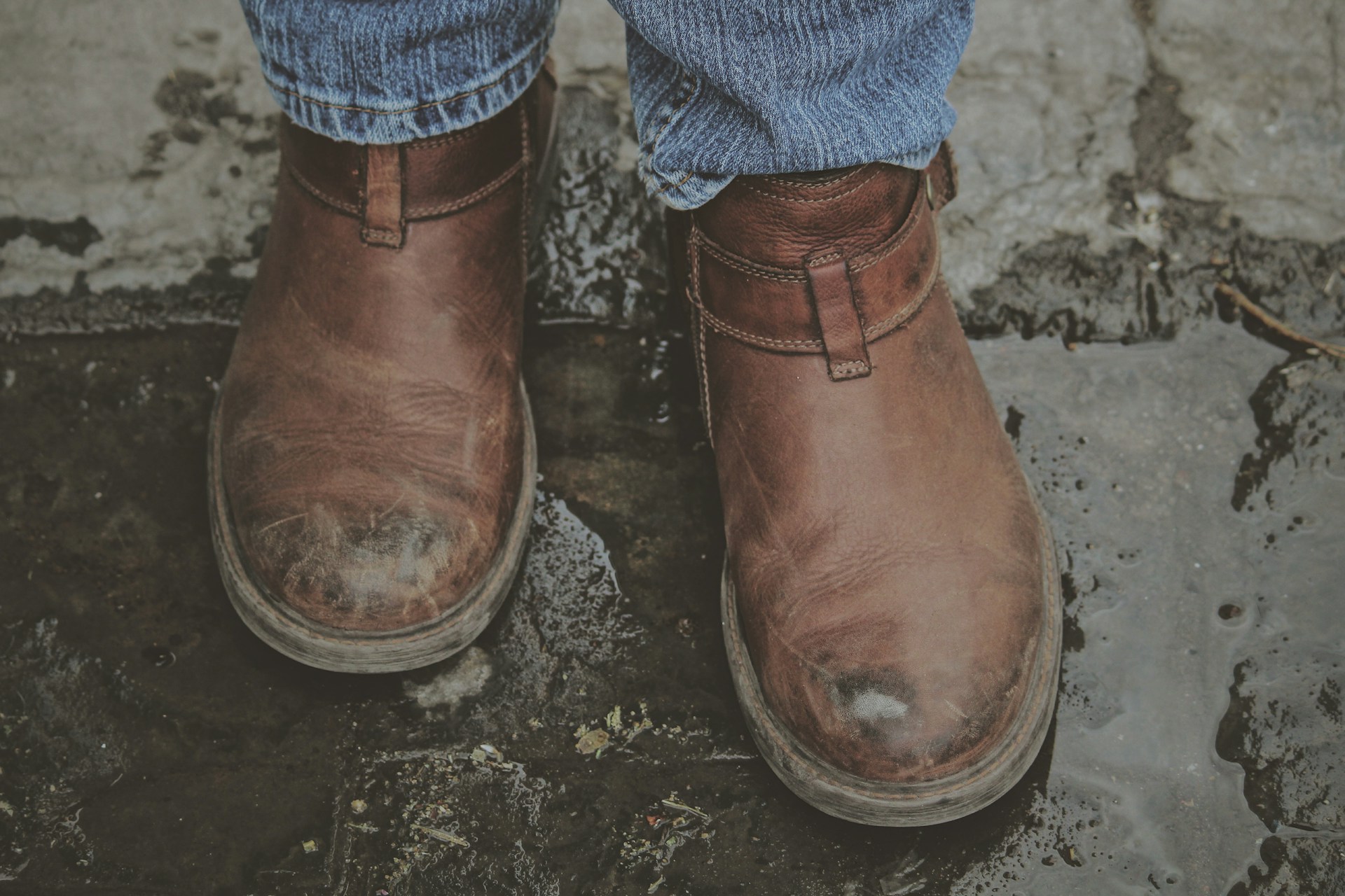 Someone wearing boots walking through a puddle | Source: Unsplash