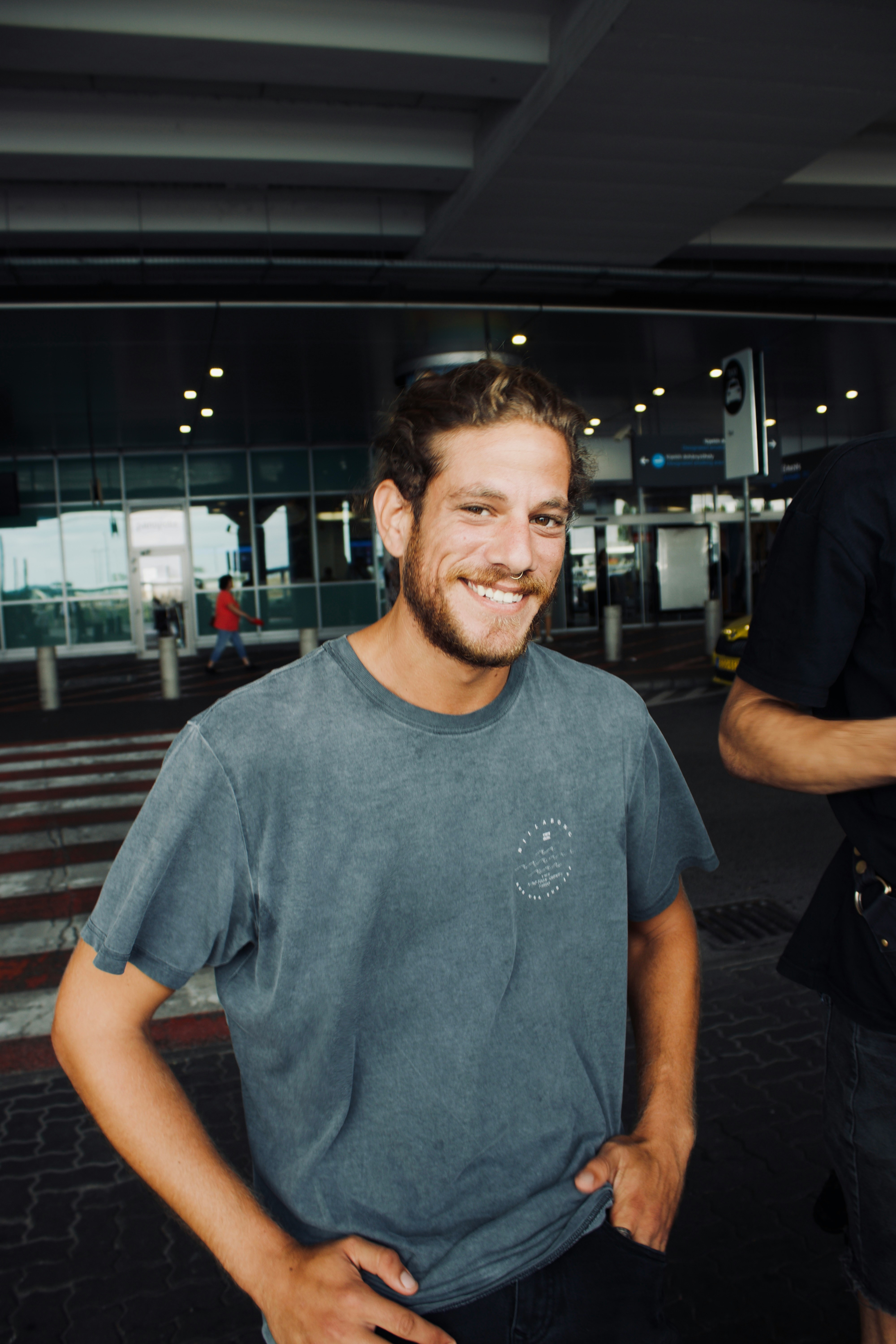 Un homme souriant à l'extérieur d'un aéroport | Source : Unsplash