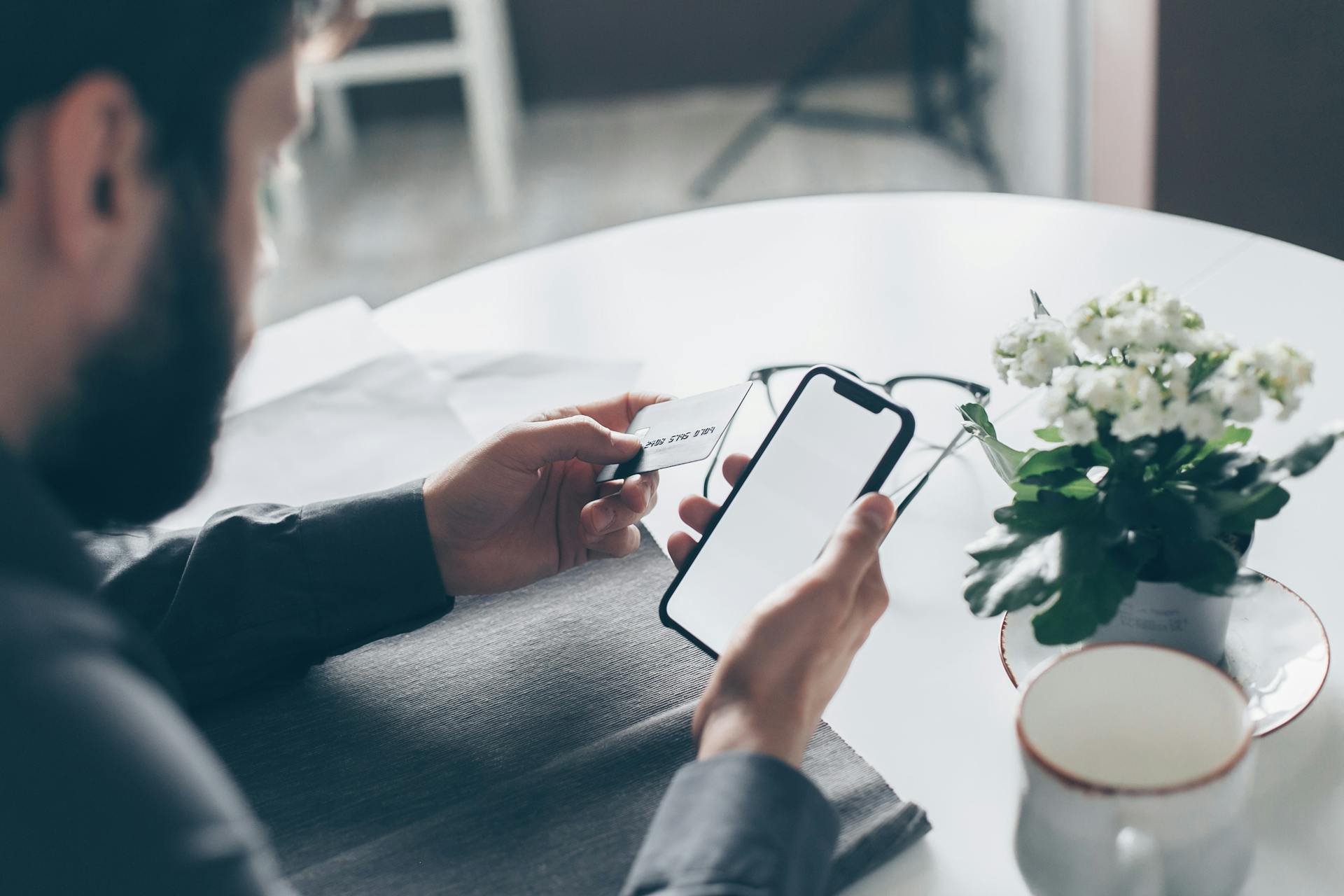 A man holding a bank card and cell phone | Source: Pexels