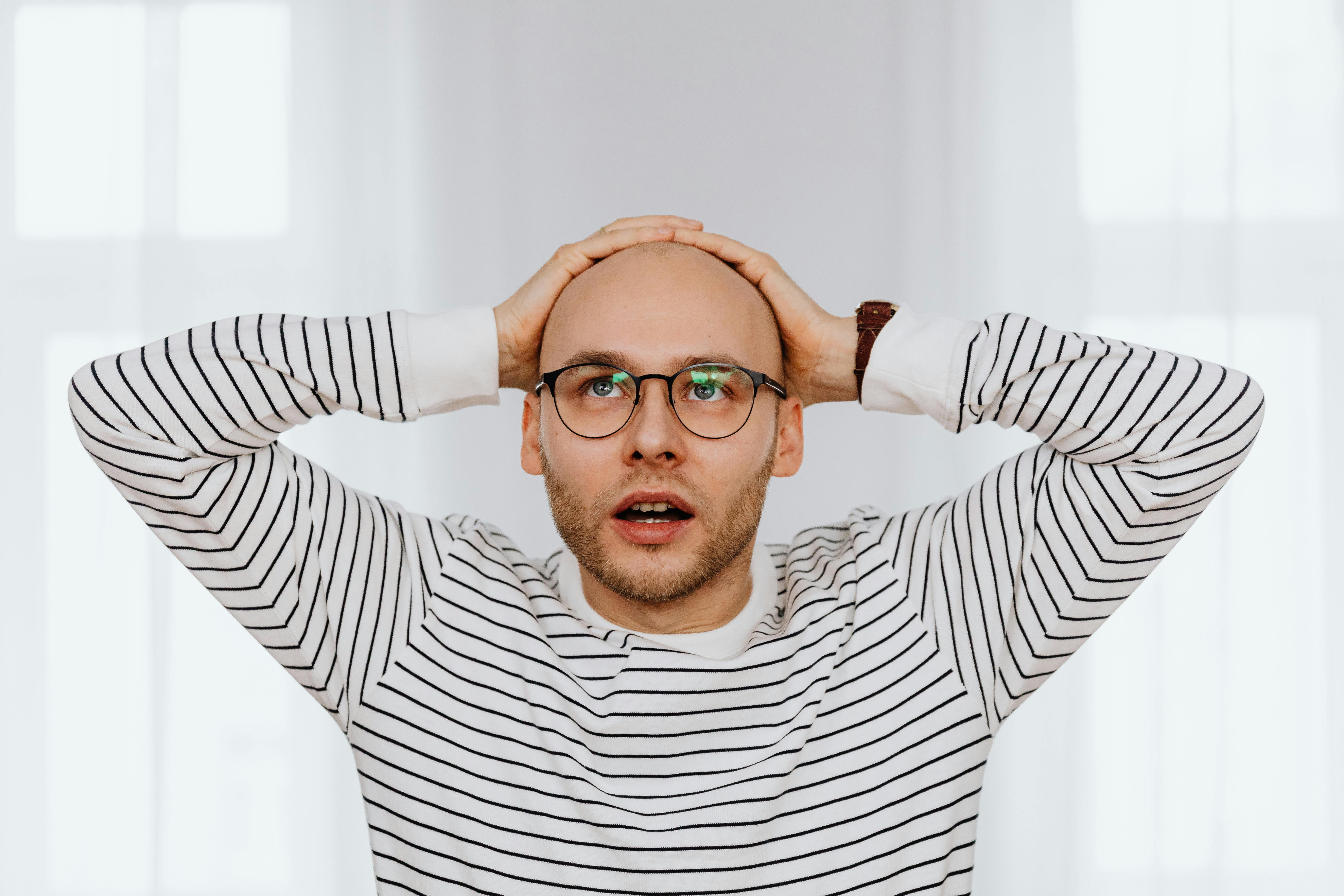 A man sitting and holding his head | Source: Pexels