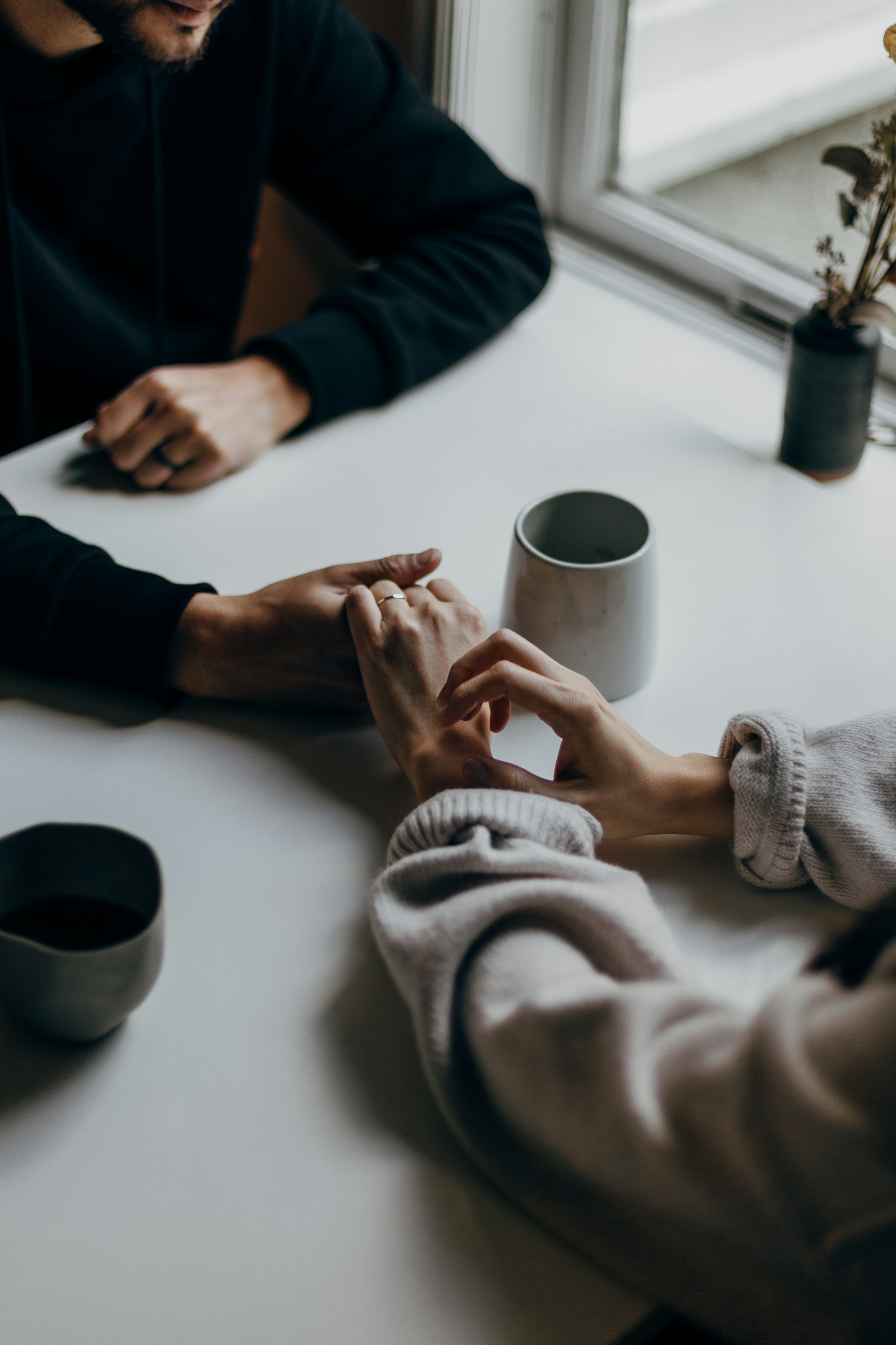 A couple holding hands across a table | Source: Unsplash