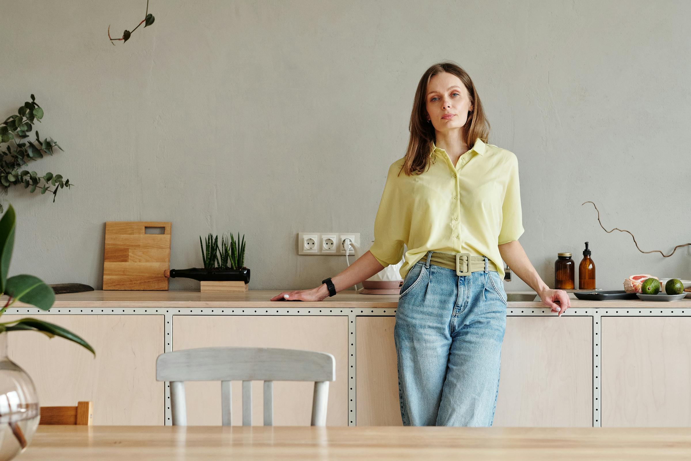 A sad woman stands in a kitchen | Source: Pexels