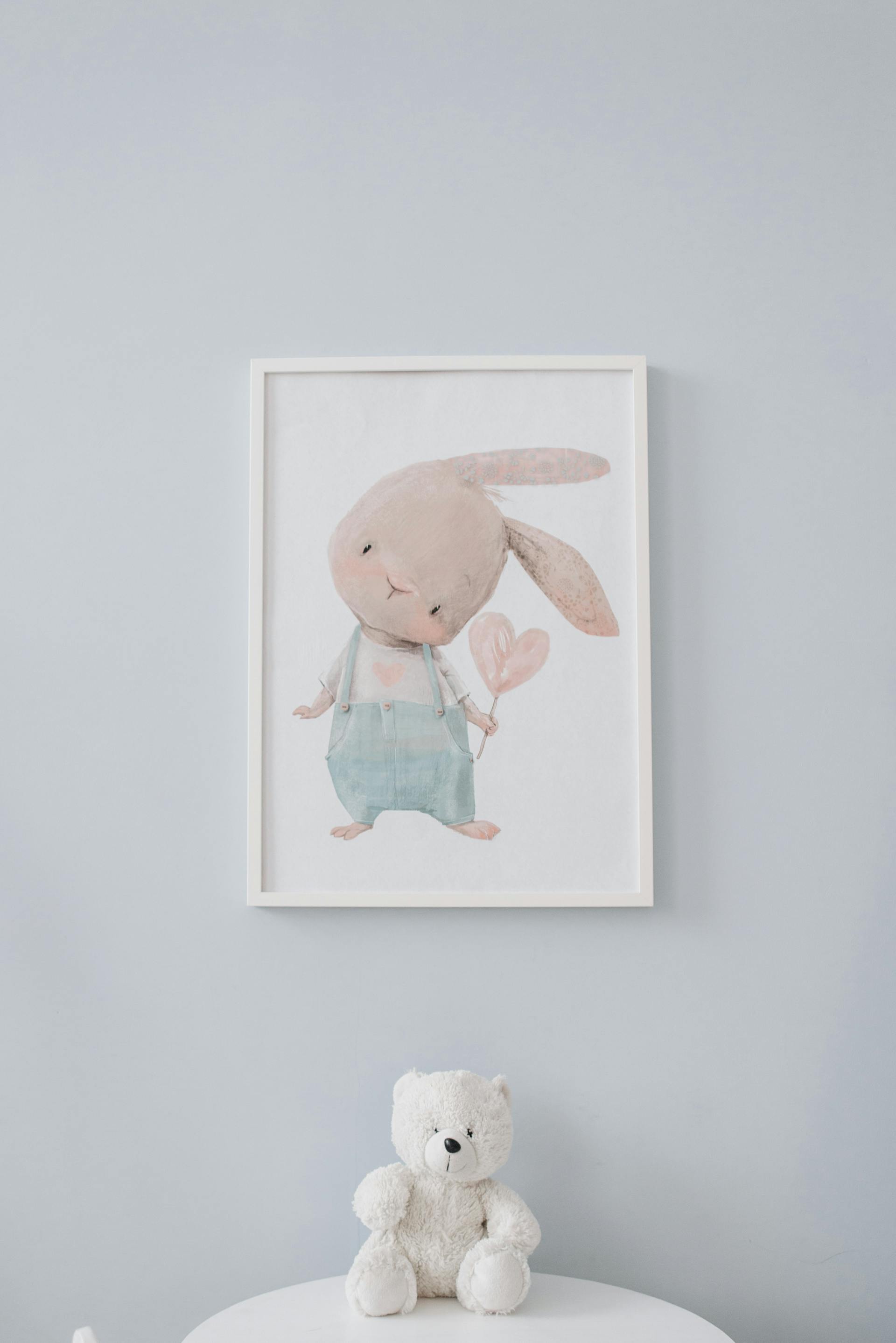 A stuffed teddy bear lying under a wall frame | Source: Pexels