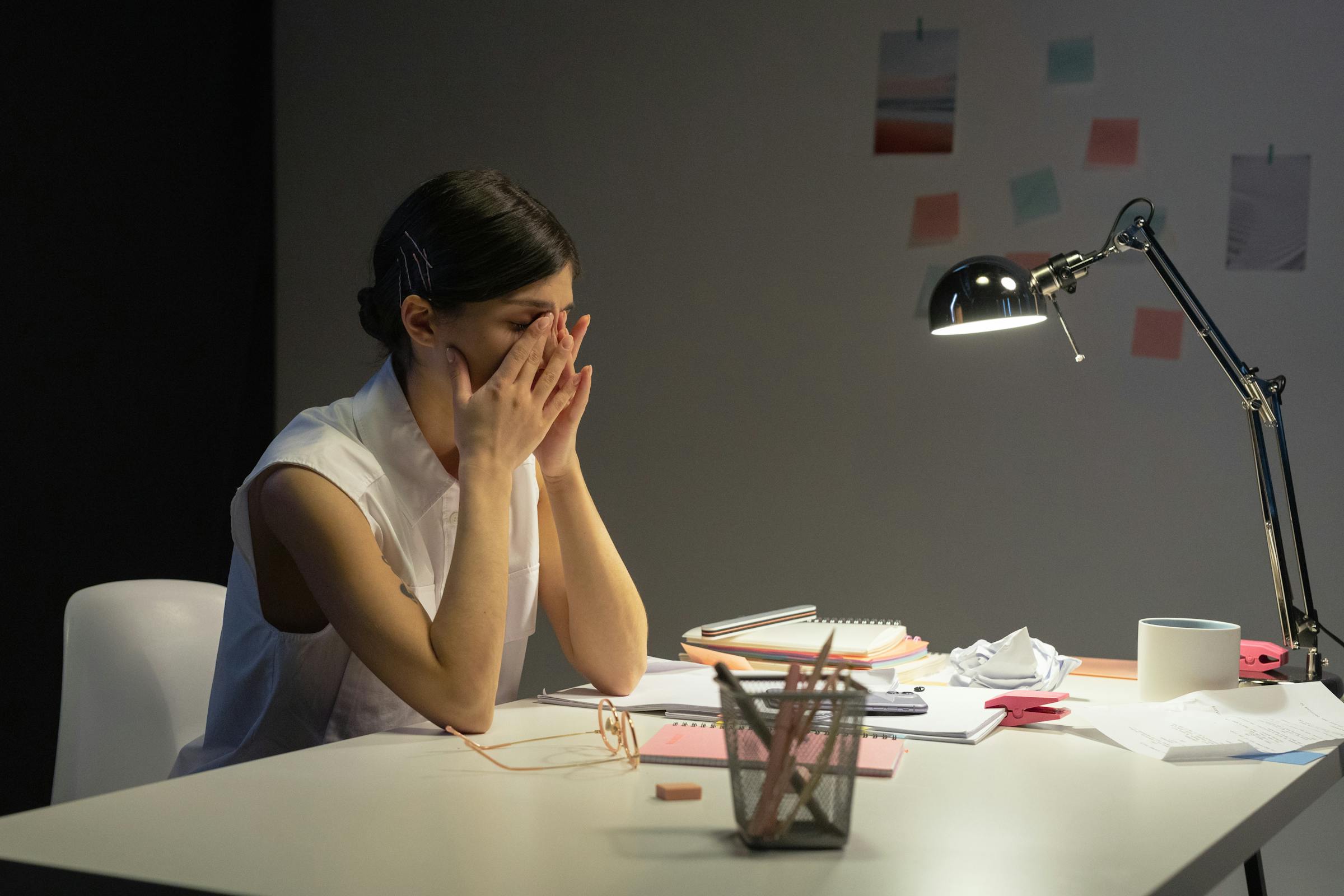 A woman sitting at a work desk looking tired | Source: Pexels