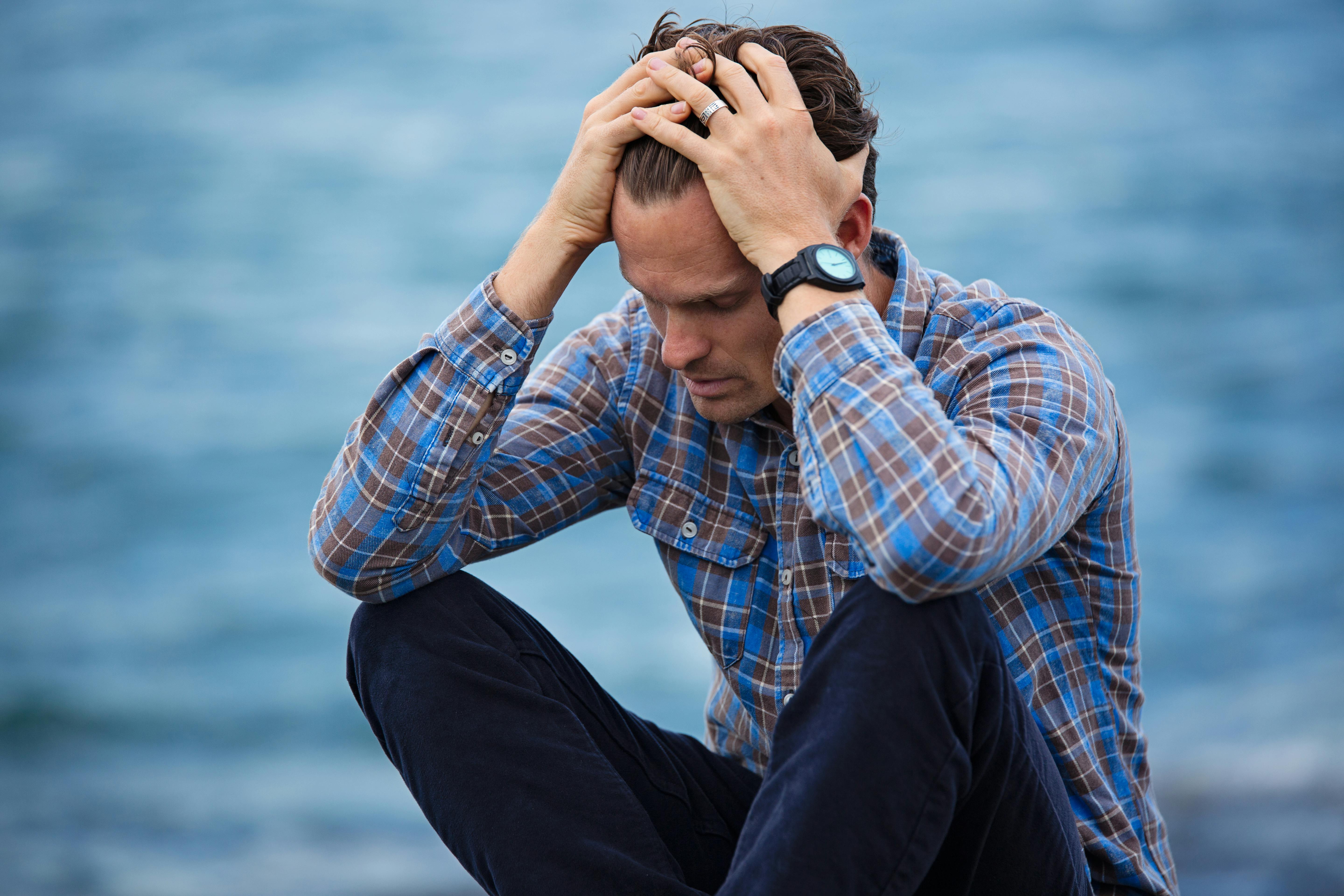 An upset man holding his head | Source: Pexels