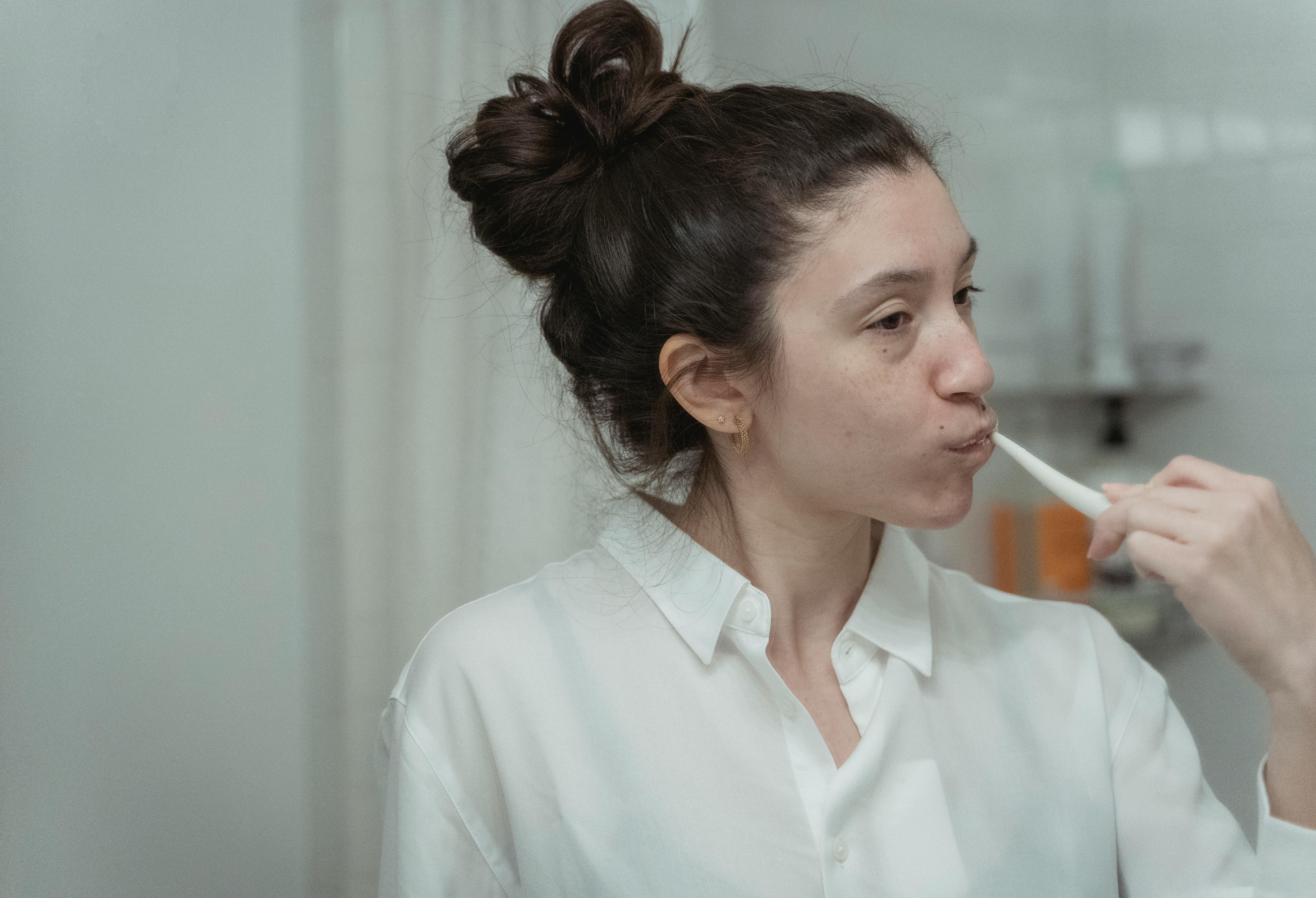 A woman brushing her teeth | Source: Pexels
