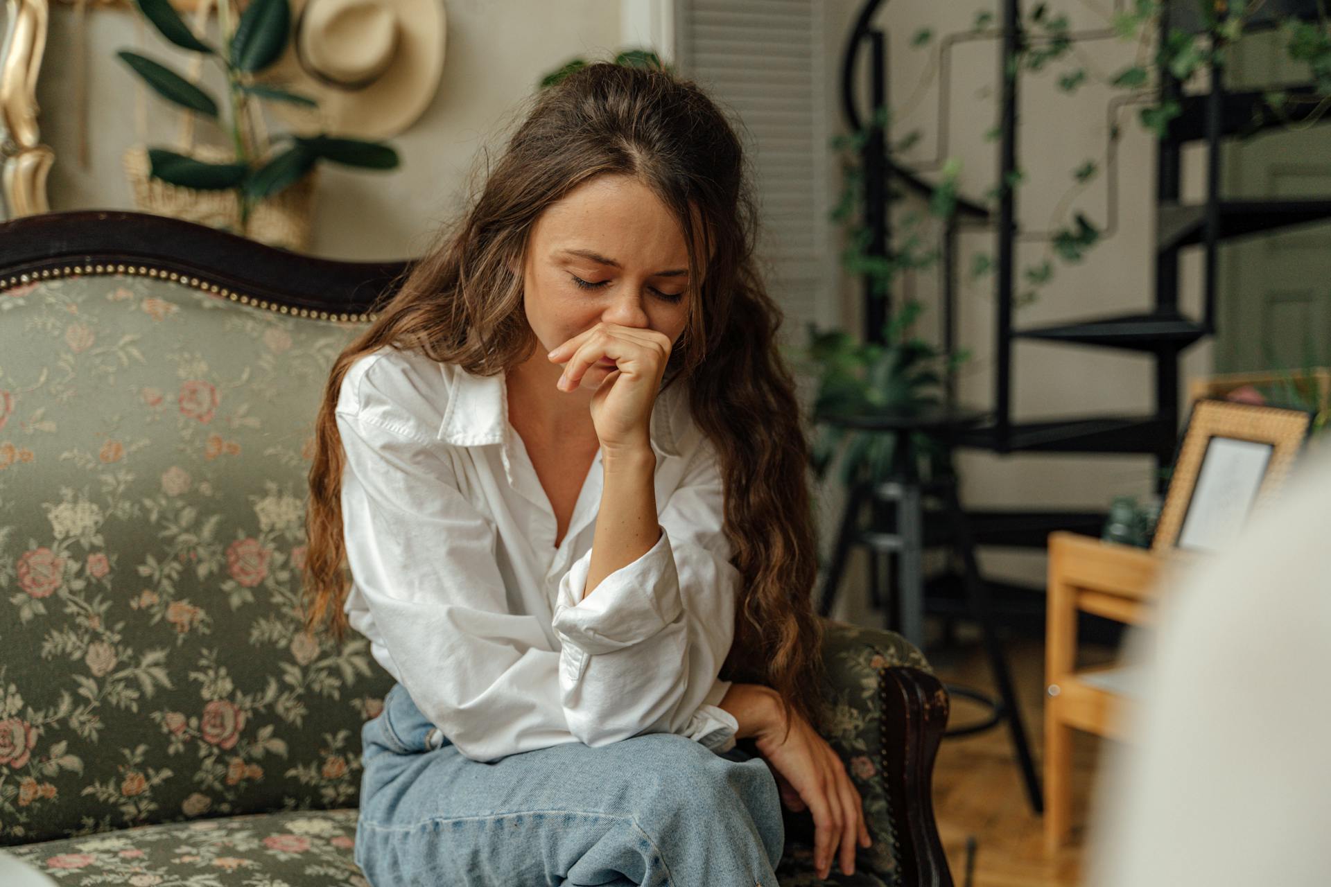 A distraught woman sitting on the sofa during a counseling session | Source: Pexels