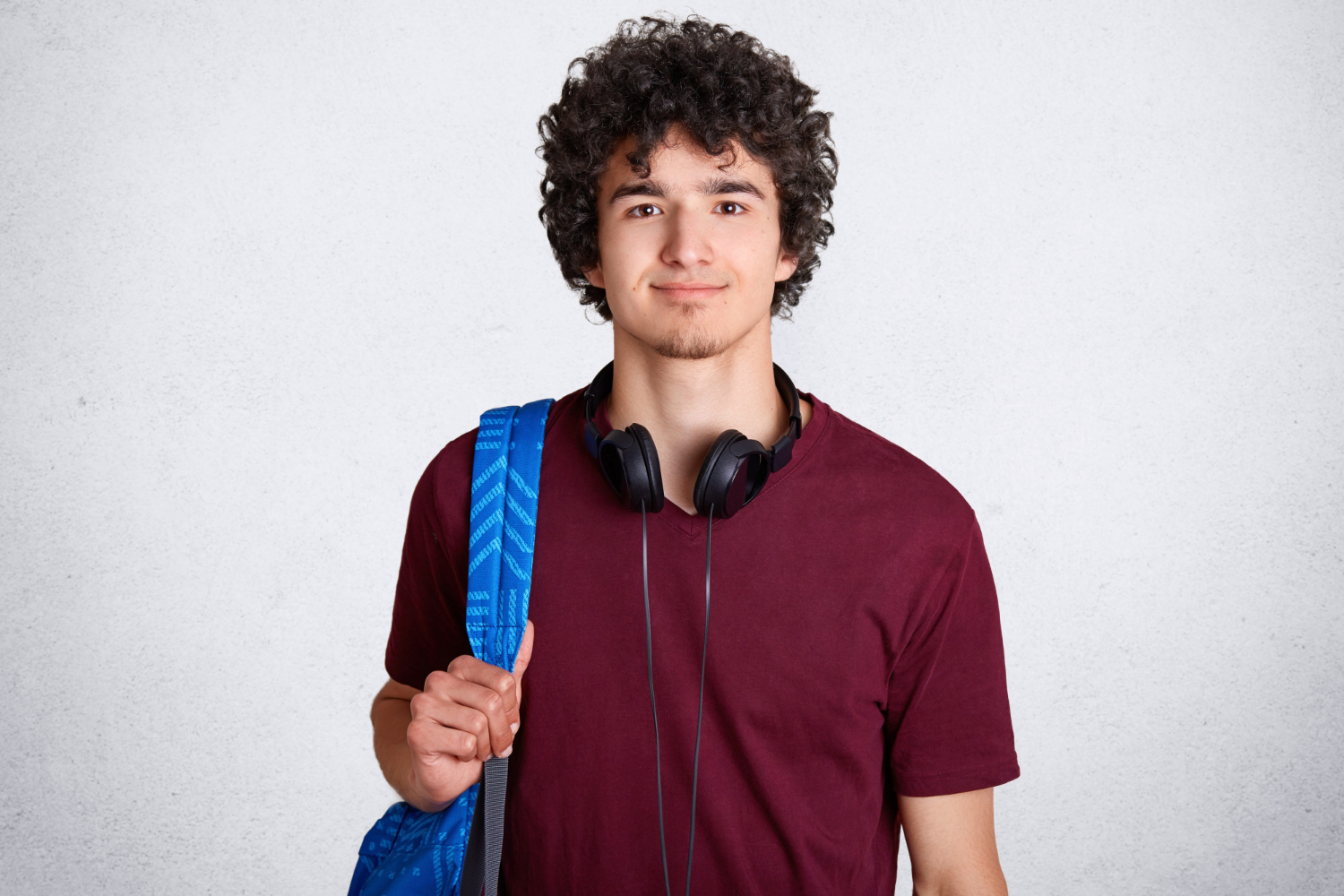 A young man holding his backpack | Source: Freepik