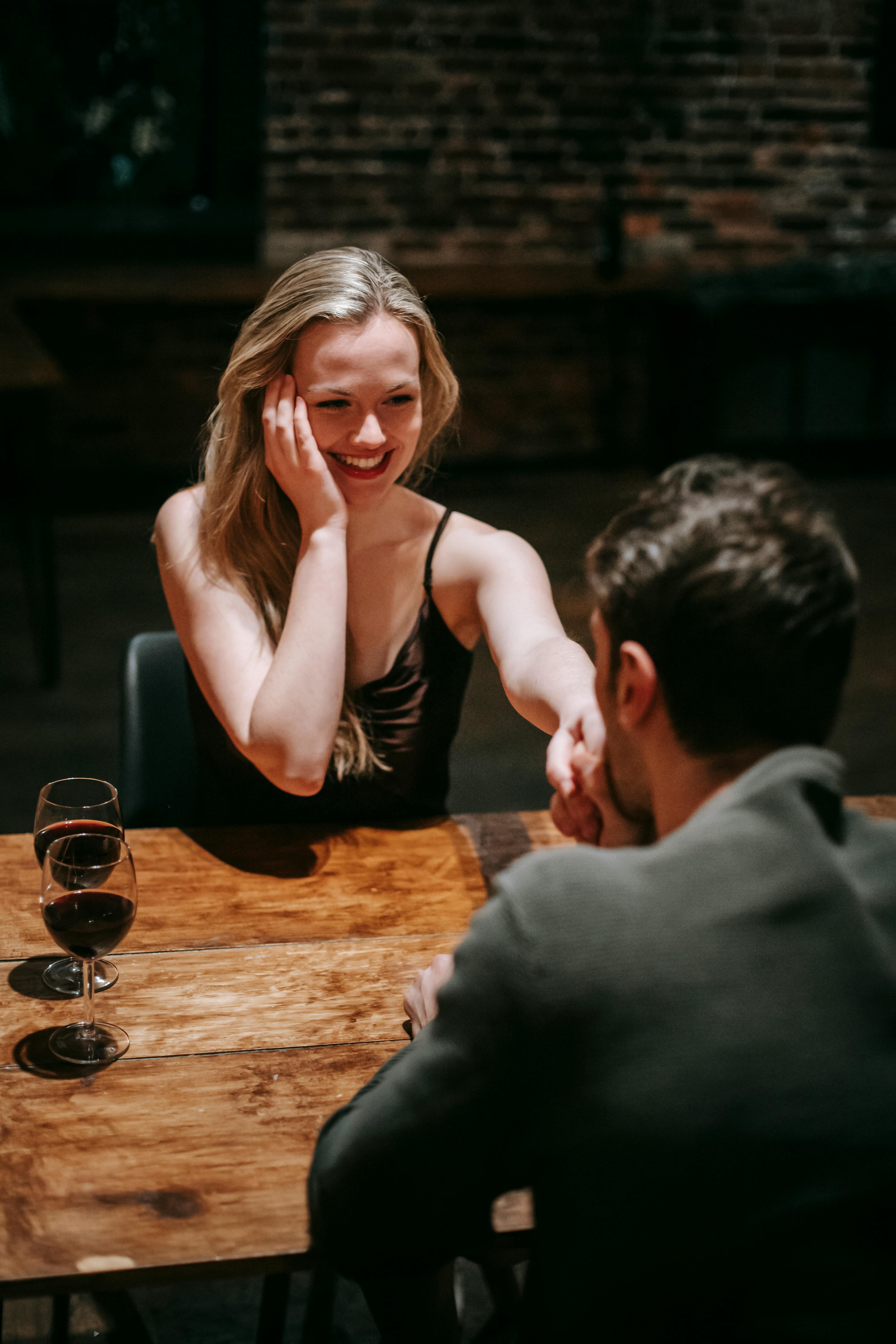 A man kissing a smiling woman's hand | Source: Pexels