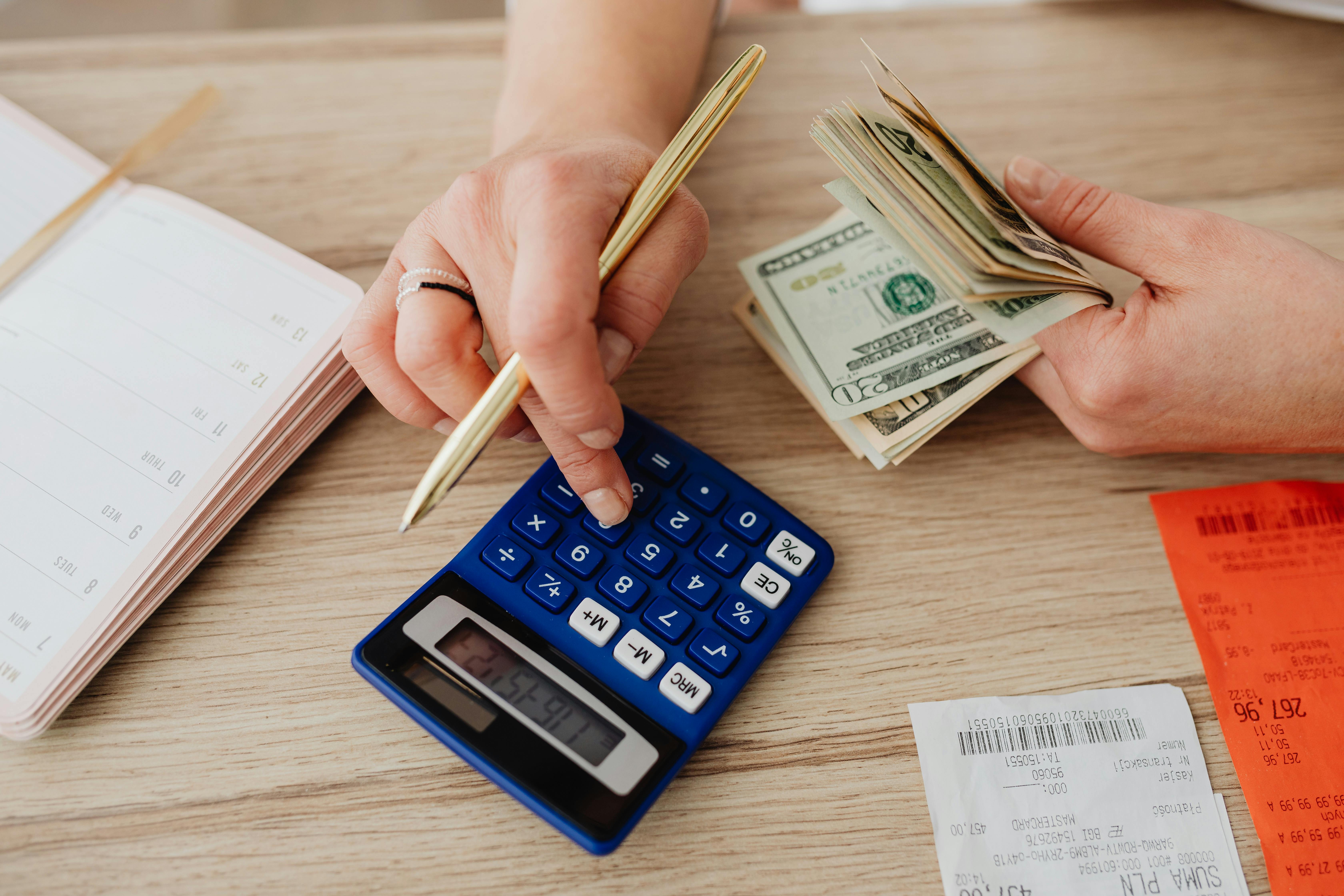A person calculating money and receipts using a calculator | Source: Pexels