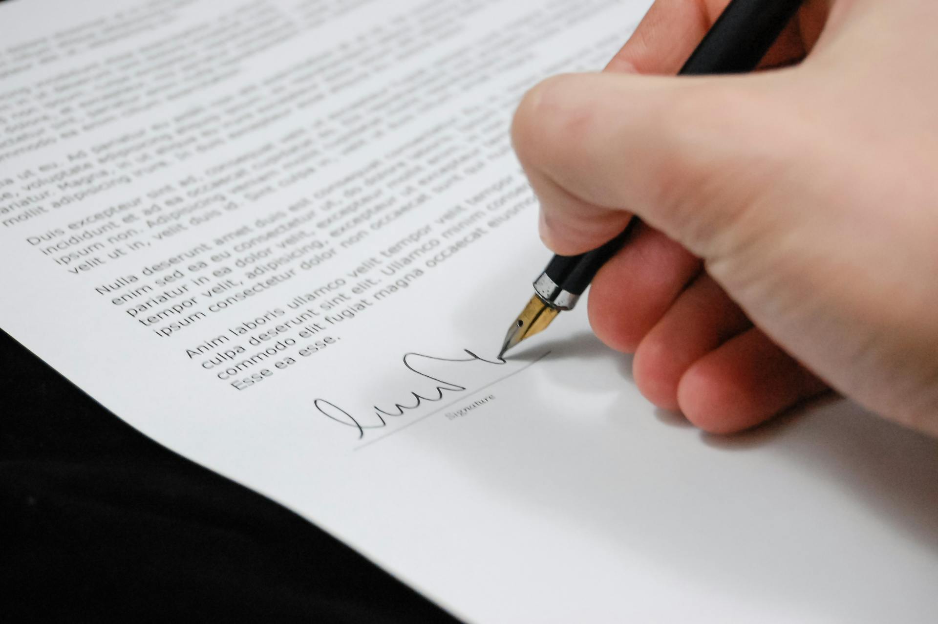 A man signing a document | Source: Pexels