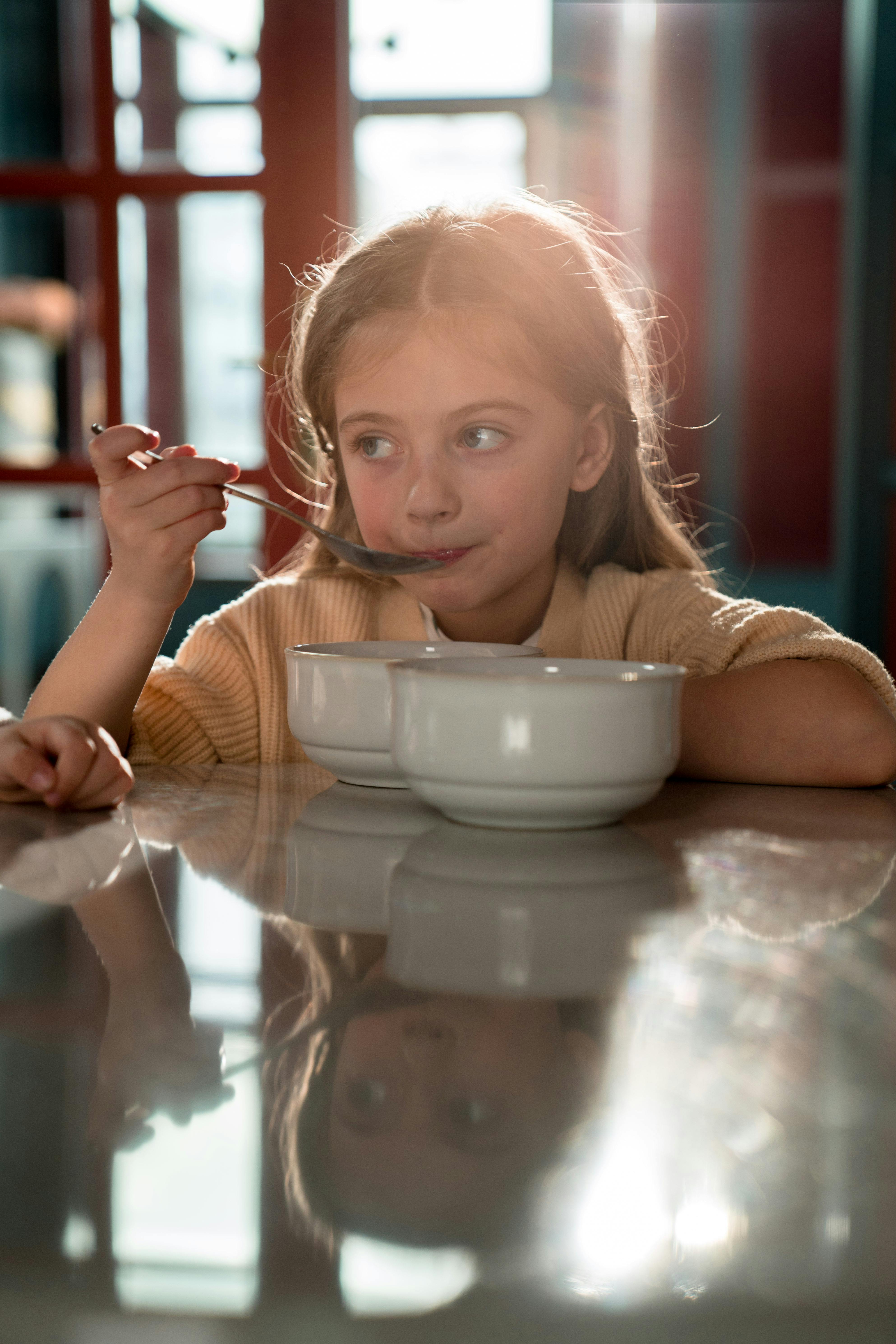 Little girl holding a silver spoon | Source: Pexels