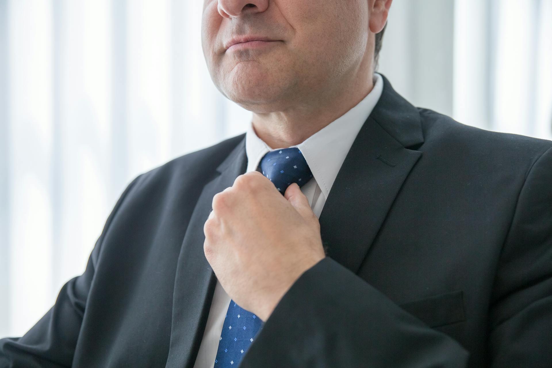 A man adjusting his tie | Source: Pexels