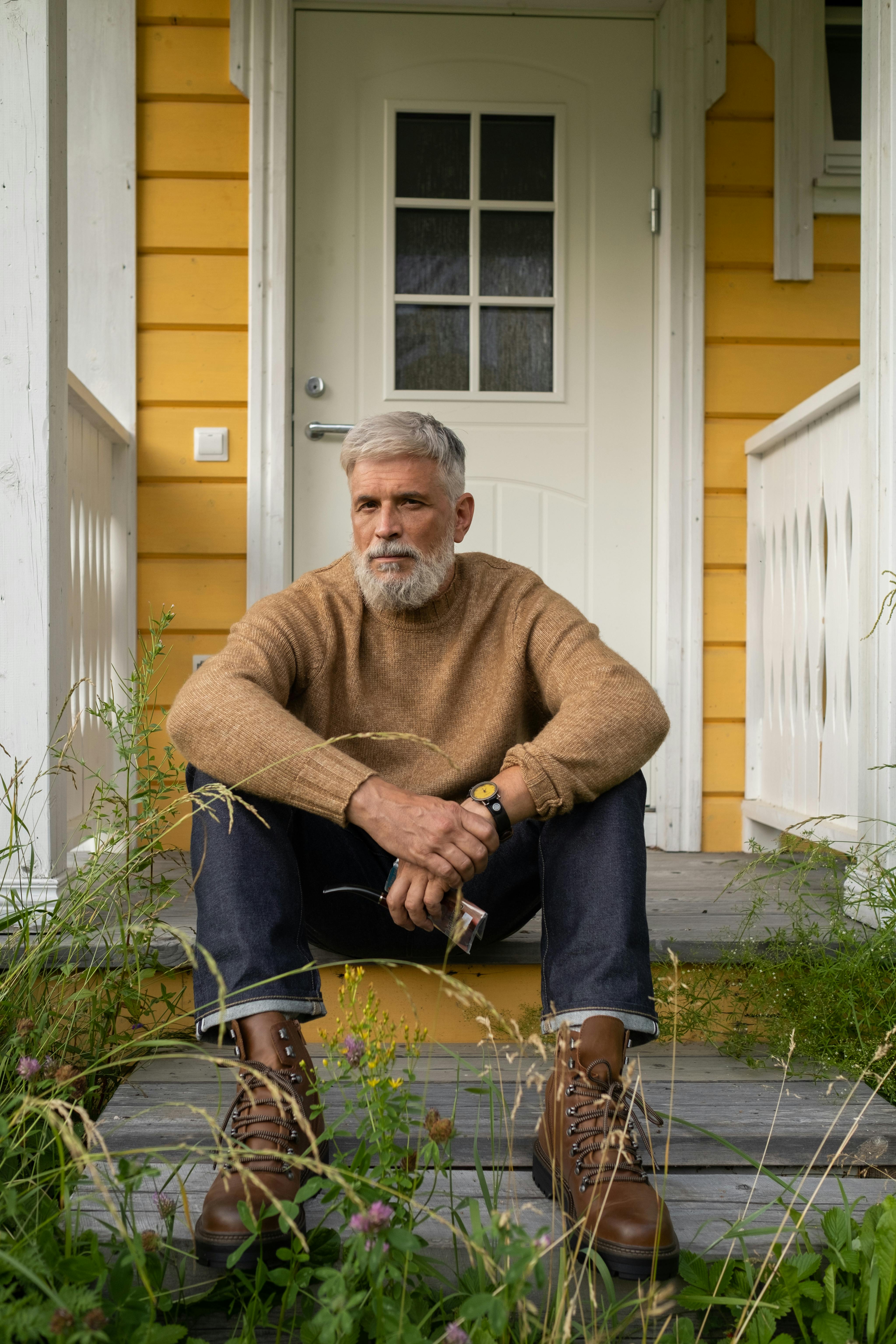 Um homem idoso sentado no degrau da varanda | Fonte: Pexels