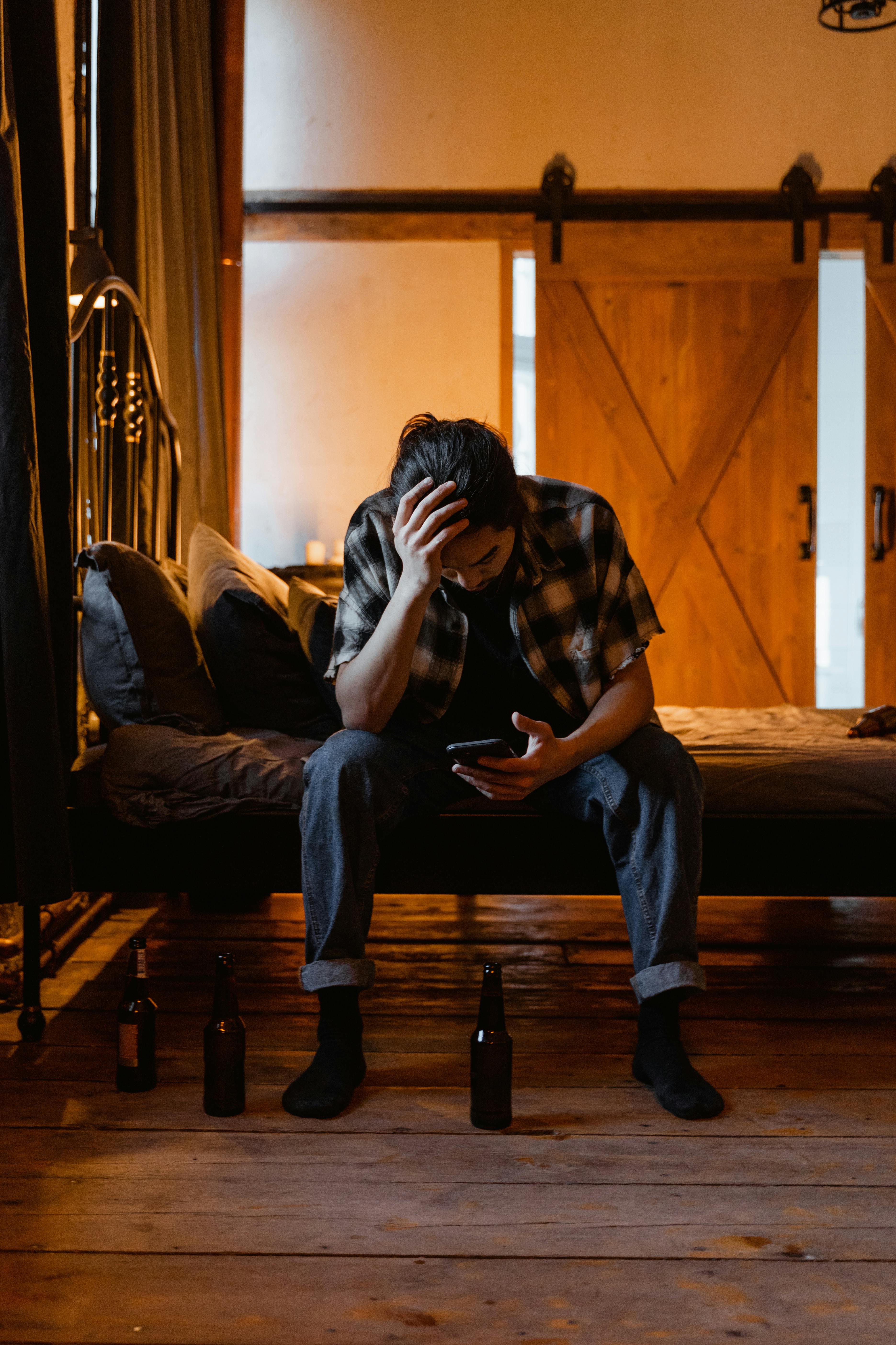 A tired man sitting on a bed | Source: Pexels