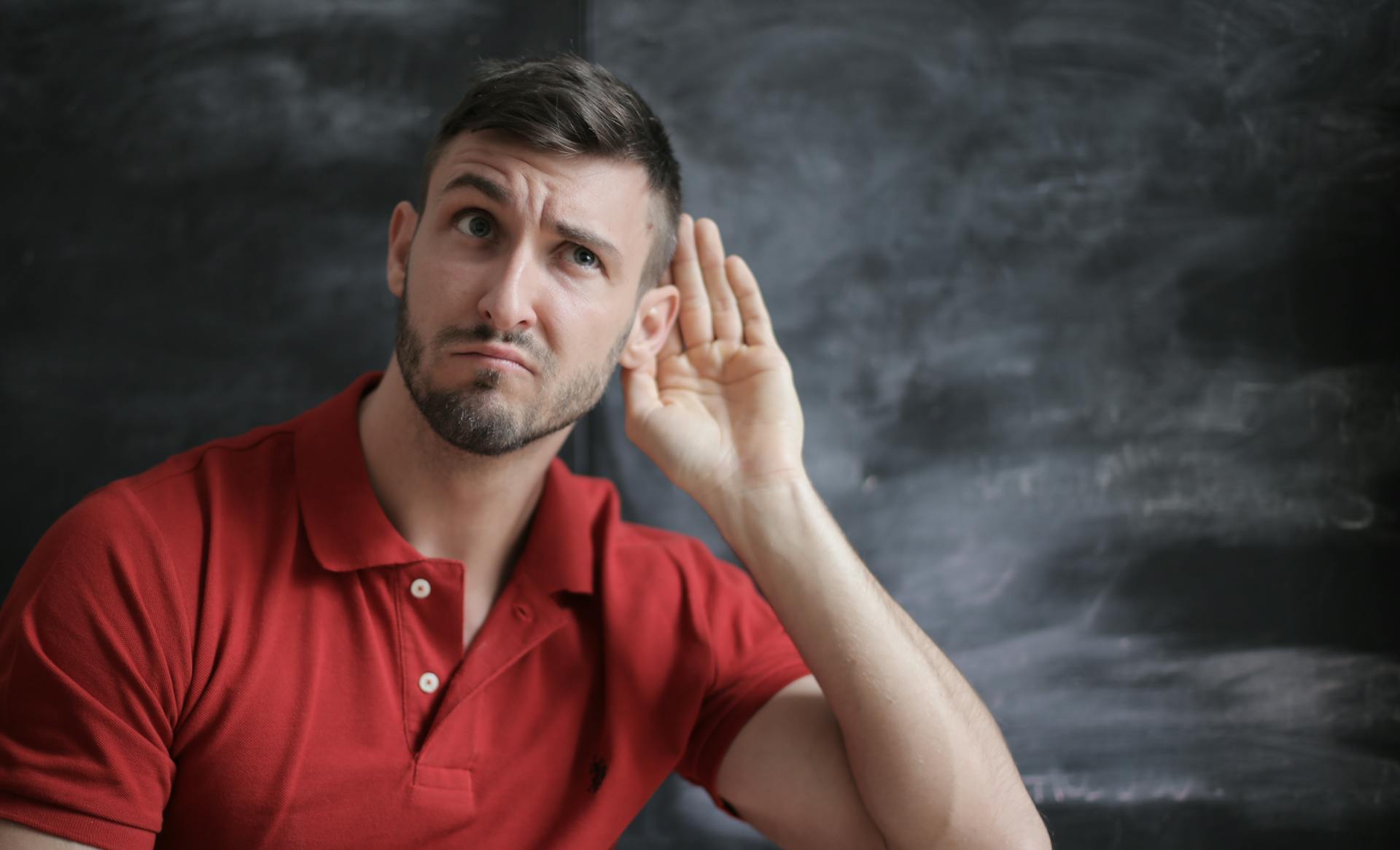 A man with his hand placed behind his ear | Source: Pexels