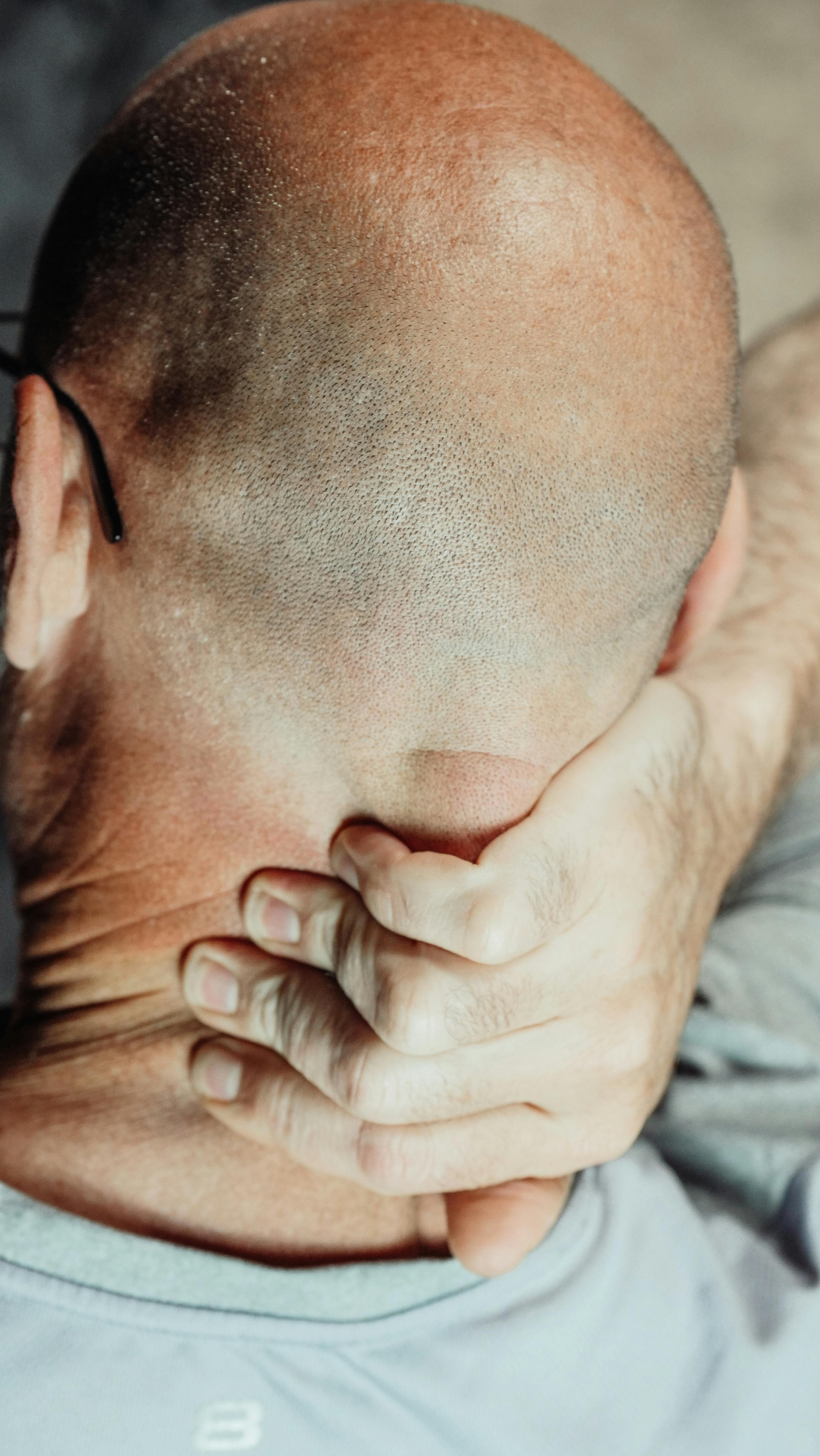 A man touching the back of his neck | Source: Pexels