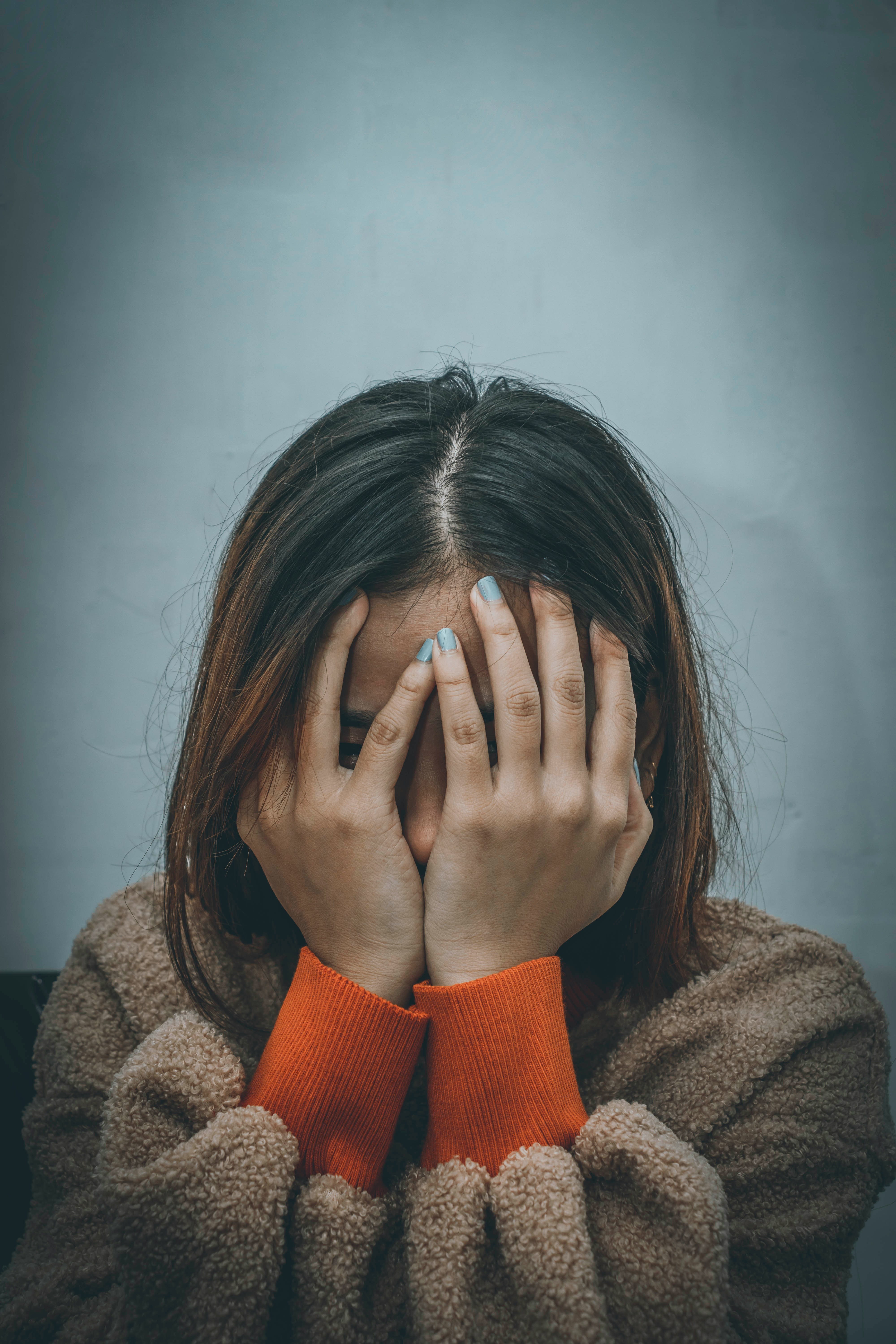 A young woman holding her face | Source: Unsplash