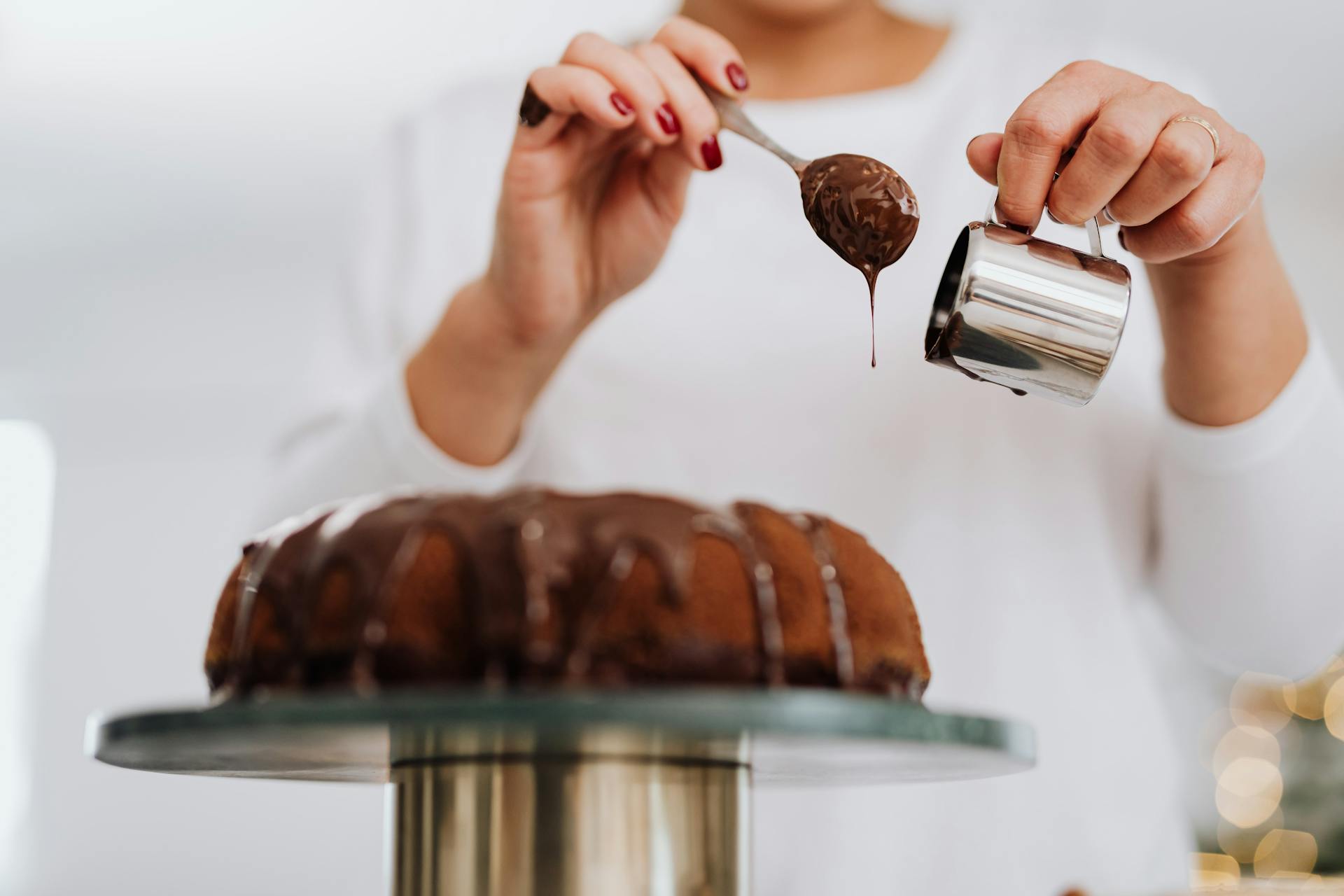 A woman decorating a cake with chocolate | Source: Pexels