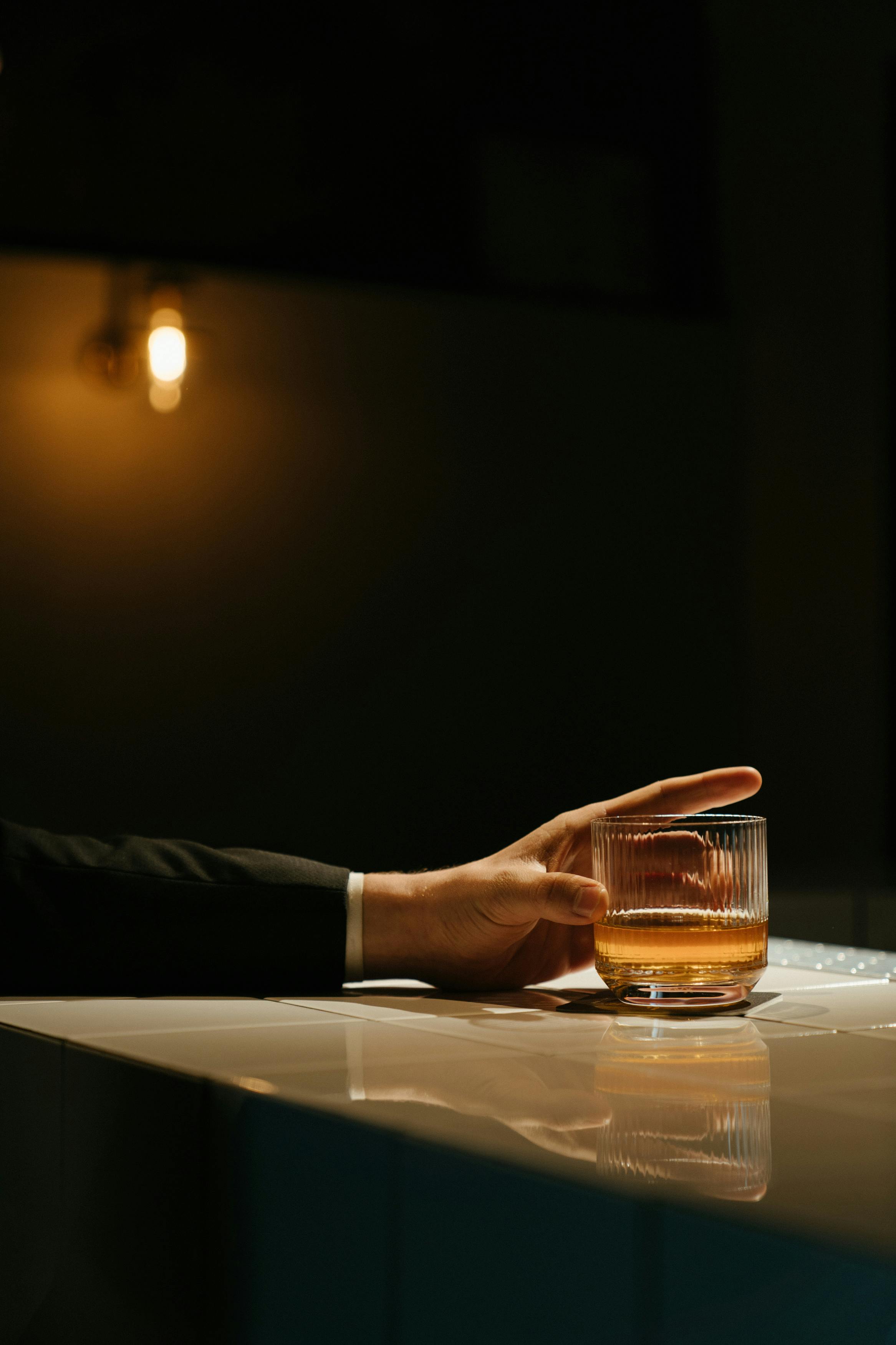 A man holding a drink at a bar | Source: Pexels