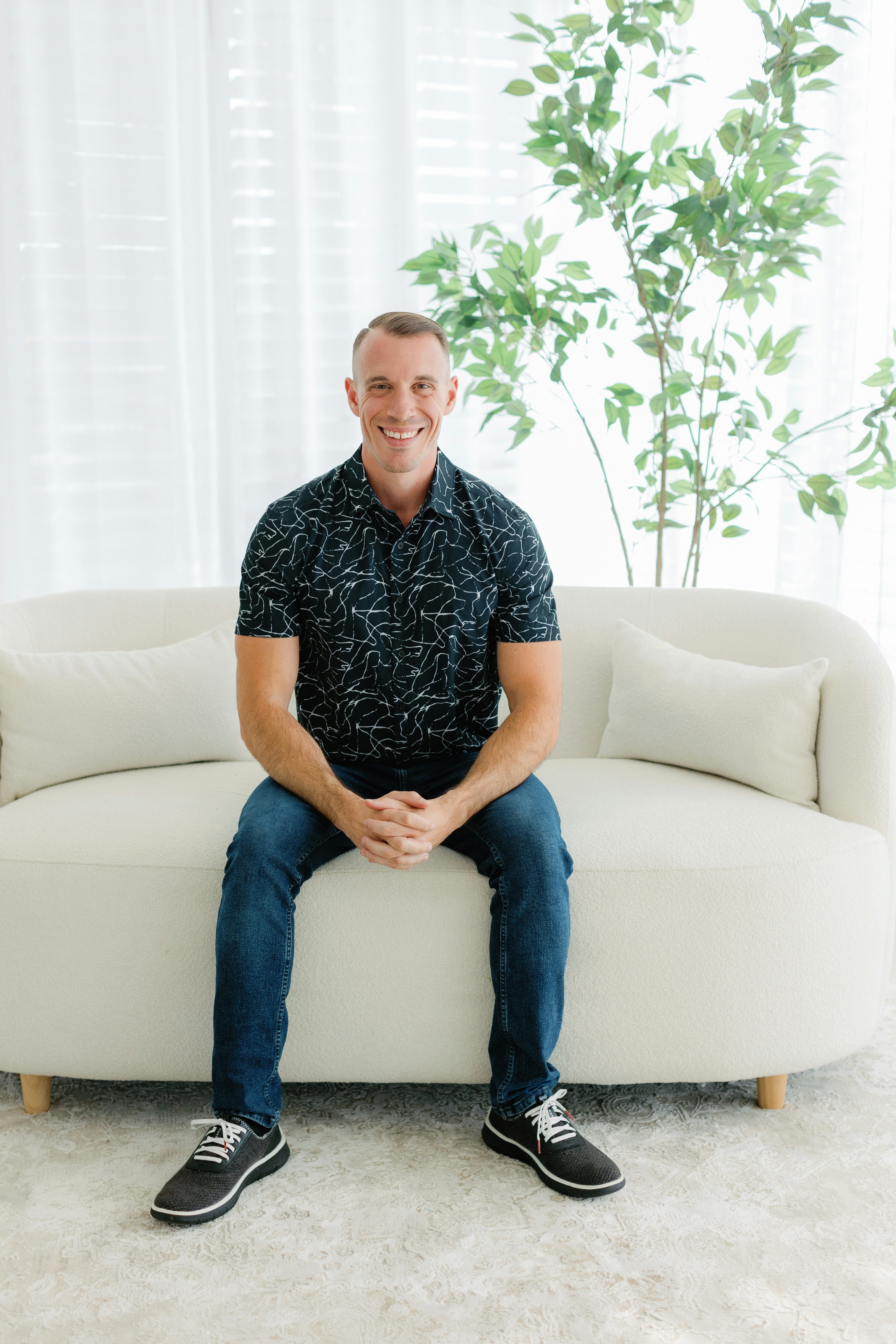 A smiling man sitting on a couch | Source: Unsplash