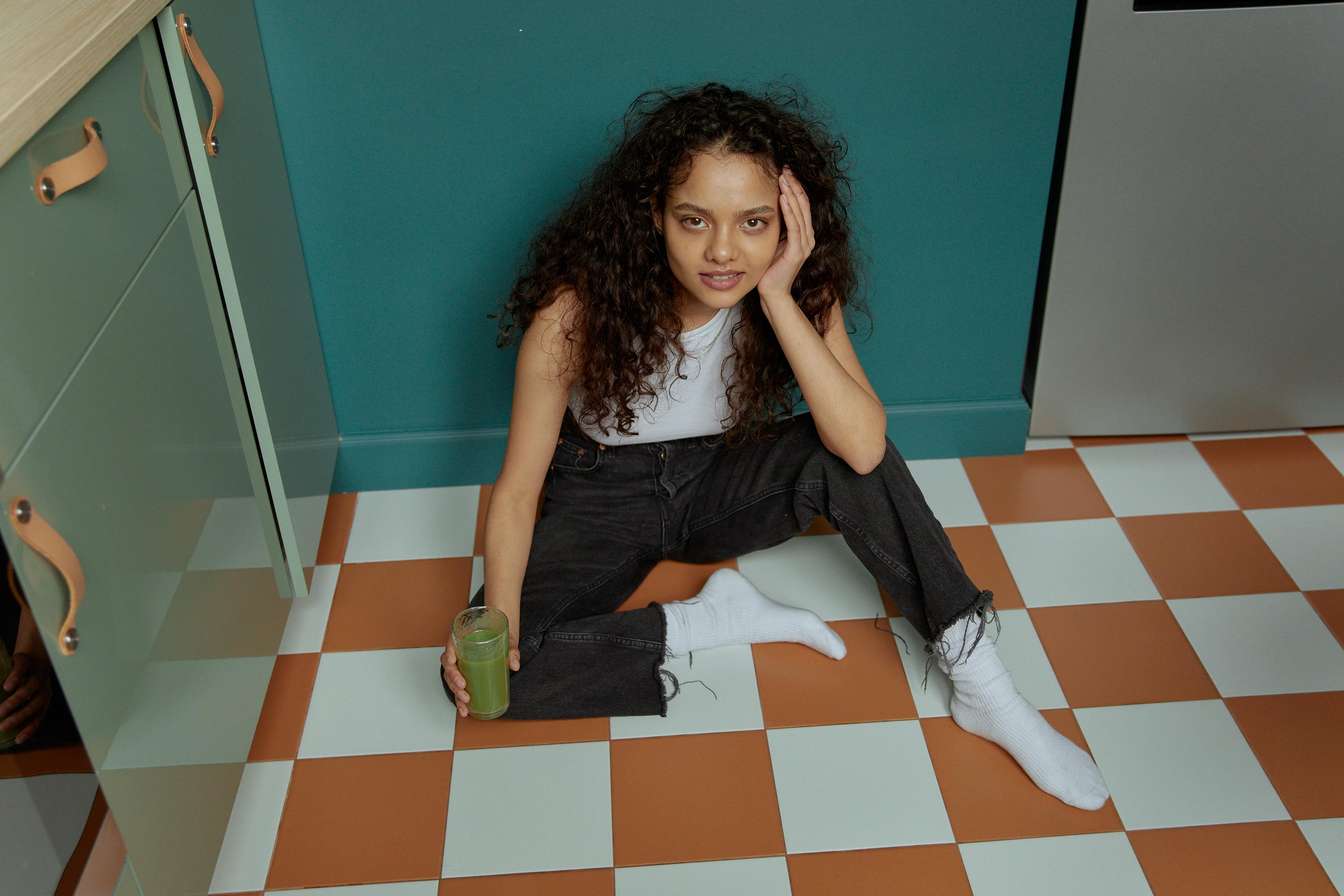 A woman sitting on a kitchen floor | Source: Pexels