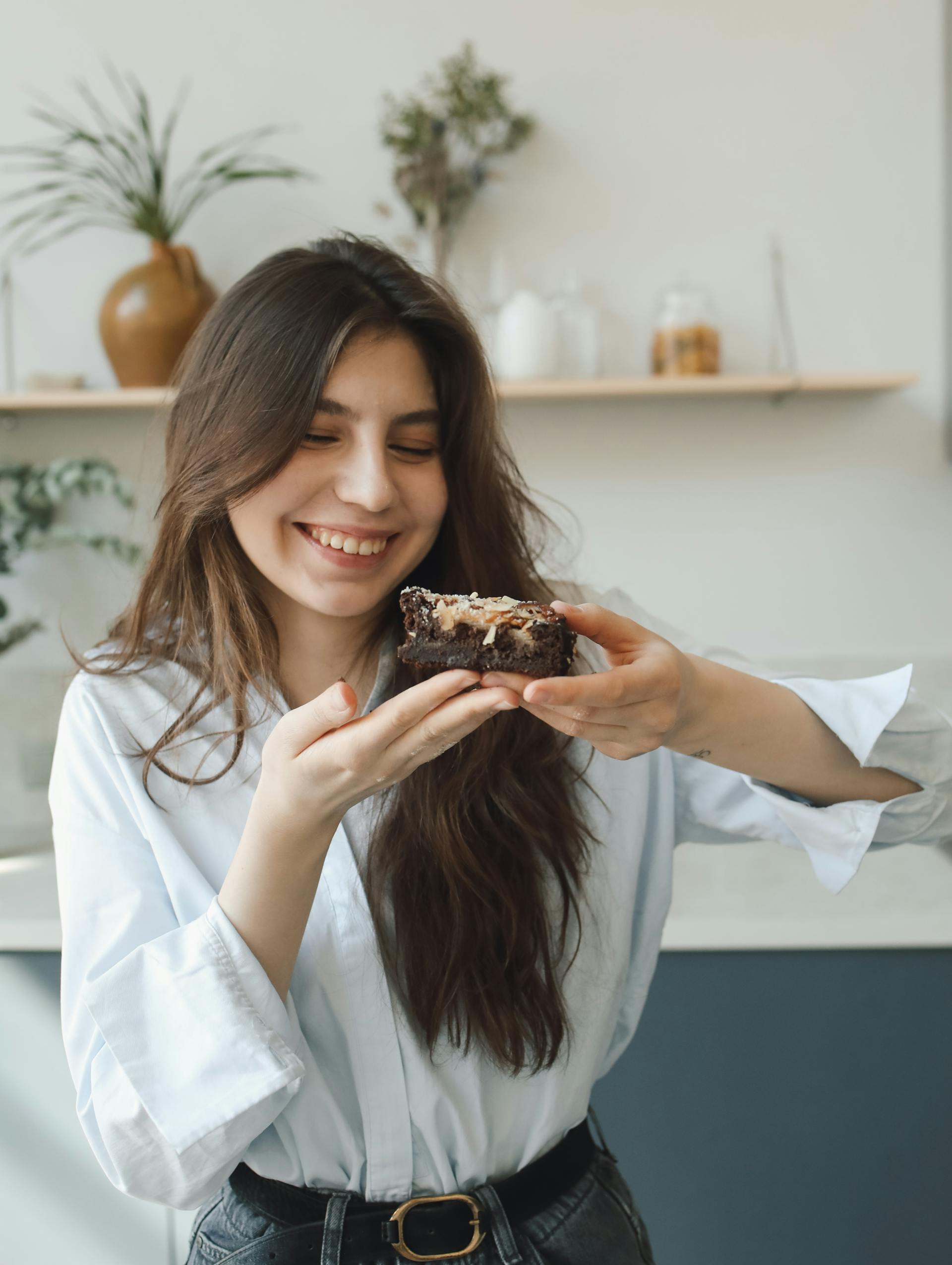 A woman holding a slice of cake | Source: Pexels