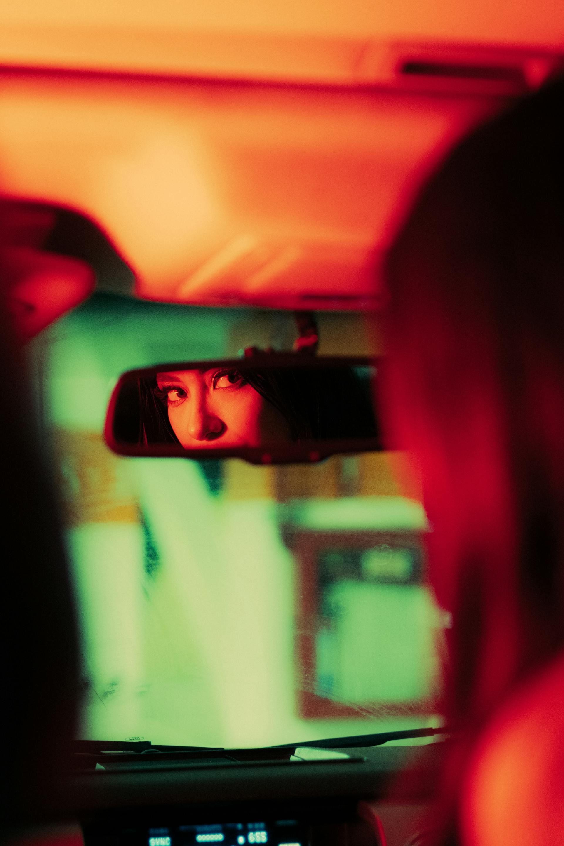 A woman using the rearview mirror in a car | Source: Pexels