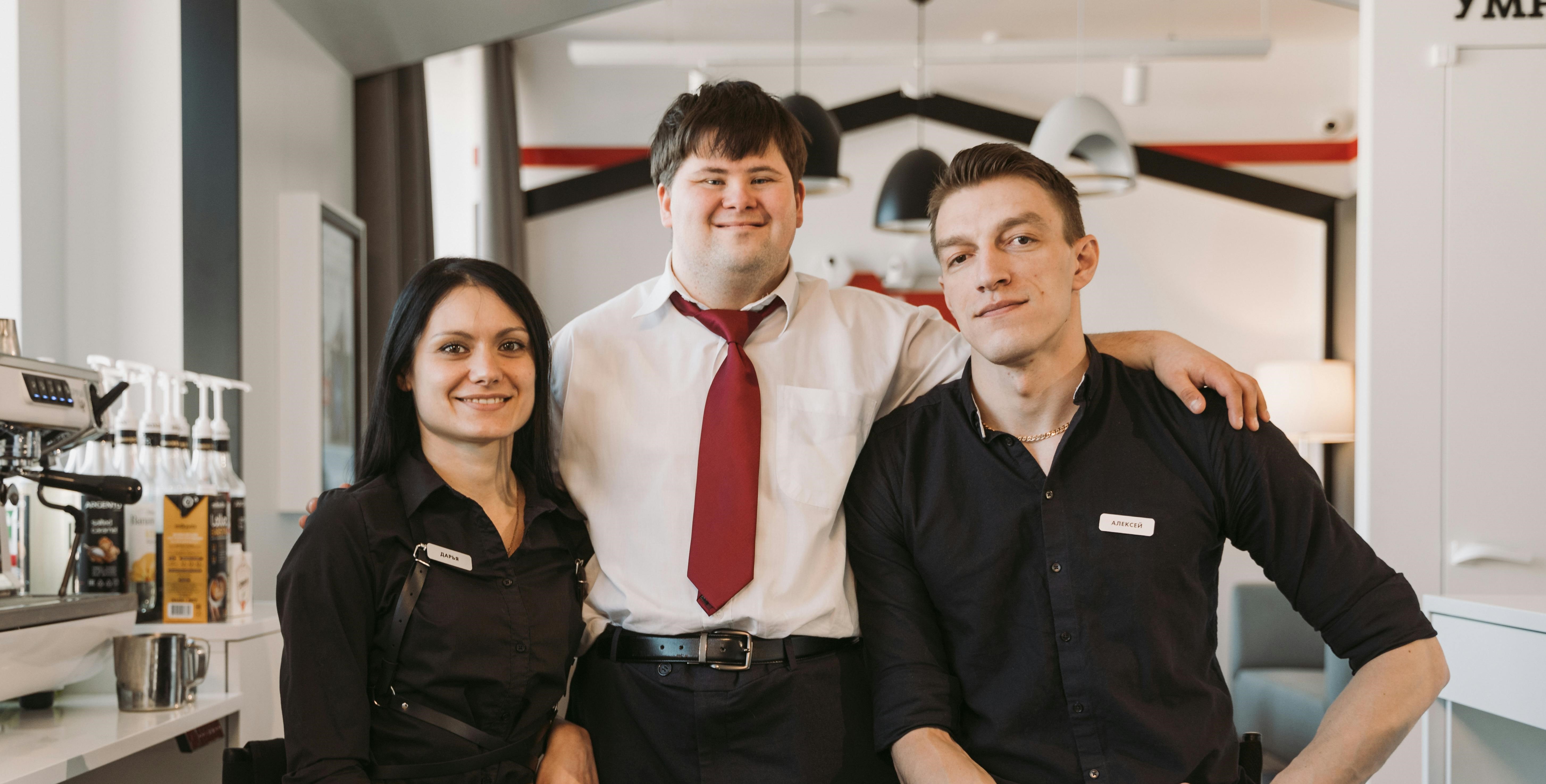 A confident manager standing proudly between his team members | Source: Pexels