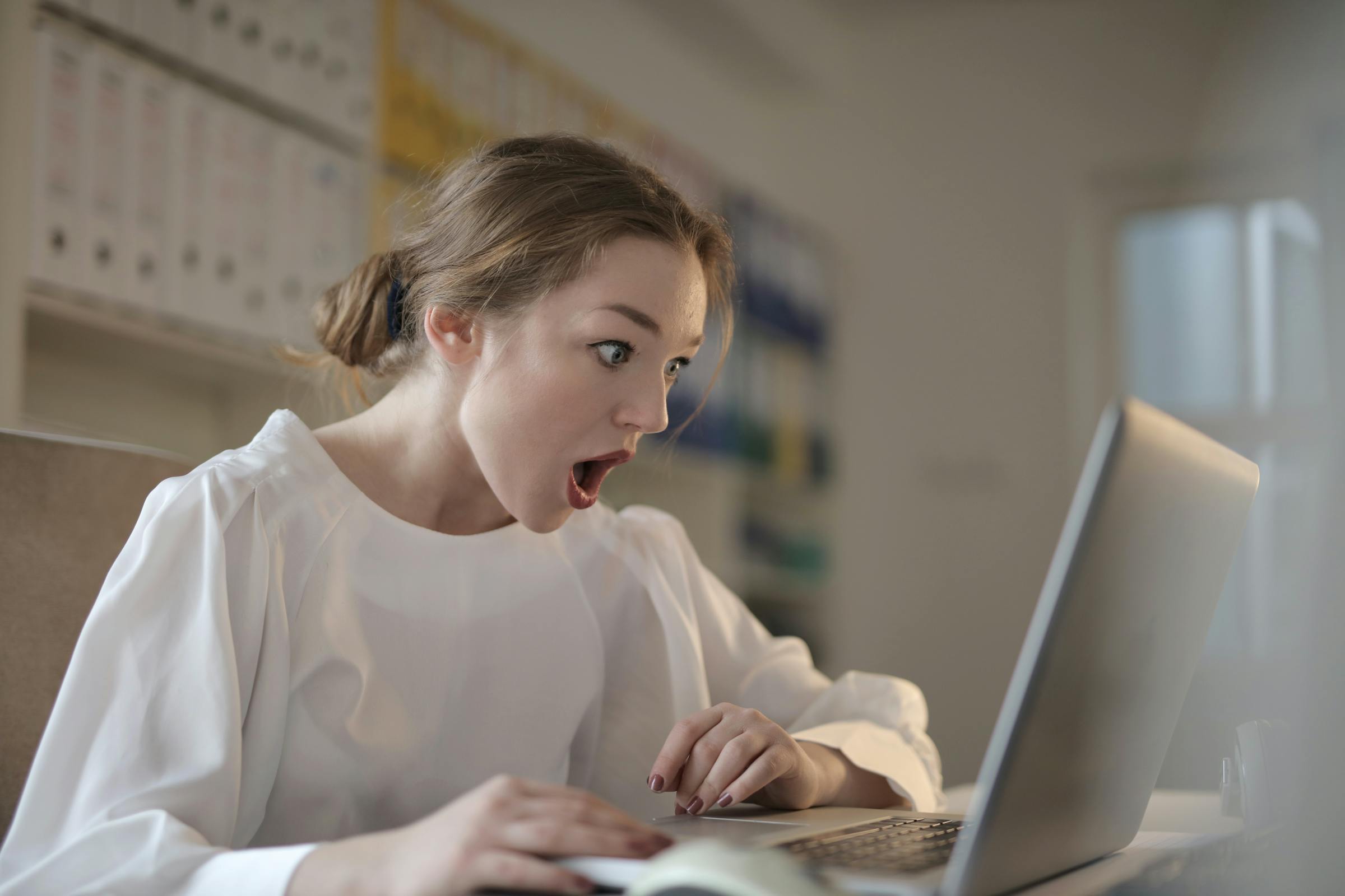 A woman staring at a computer in shock | Source: Pexels