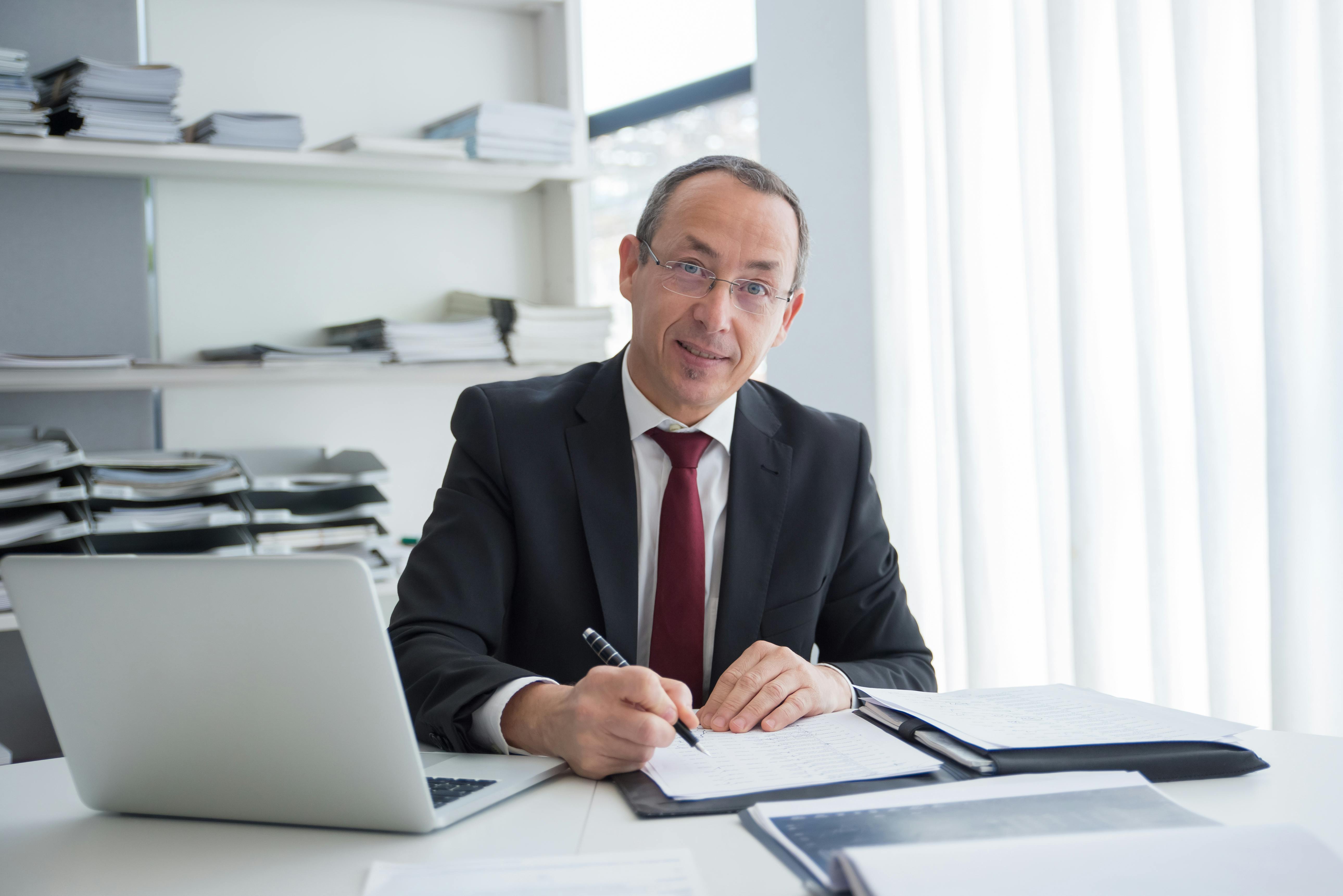 A smiling lawyer sitting at a table | Source: Pexels