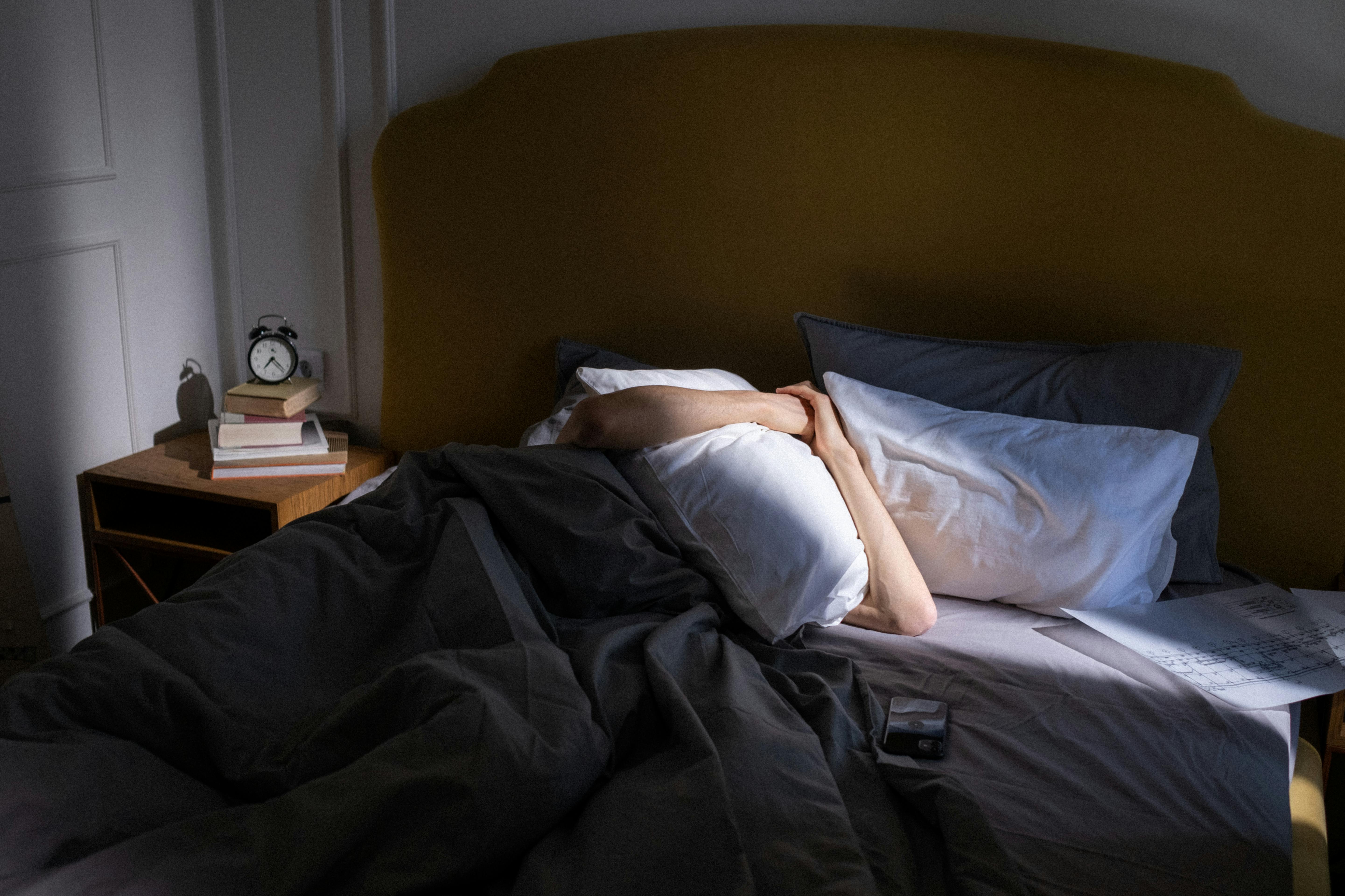 A person blocking their face with a pillow | Source: Pexels