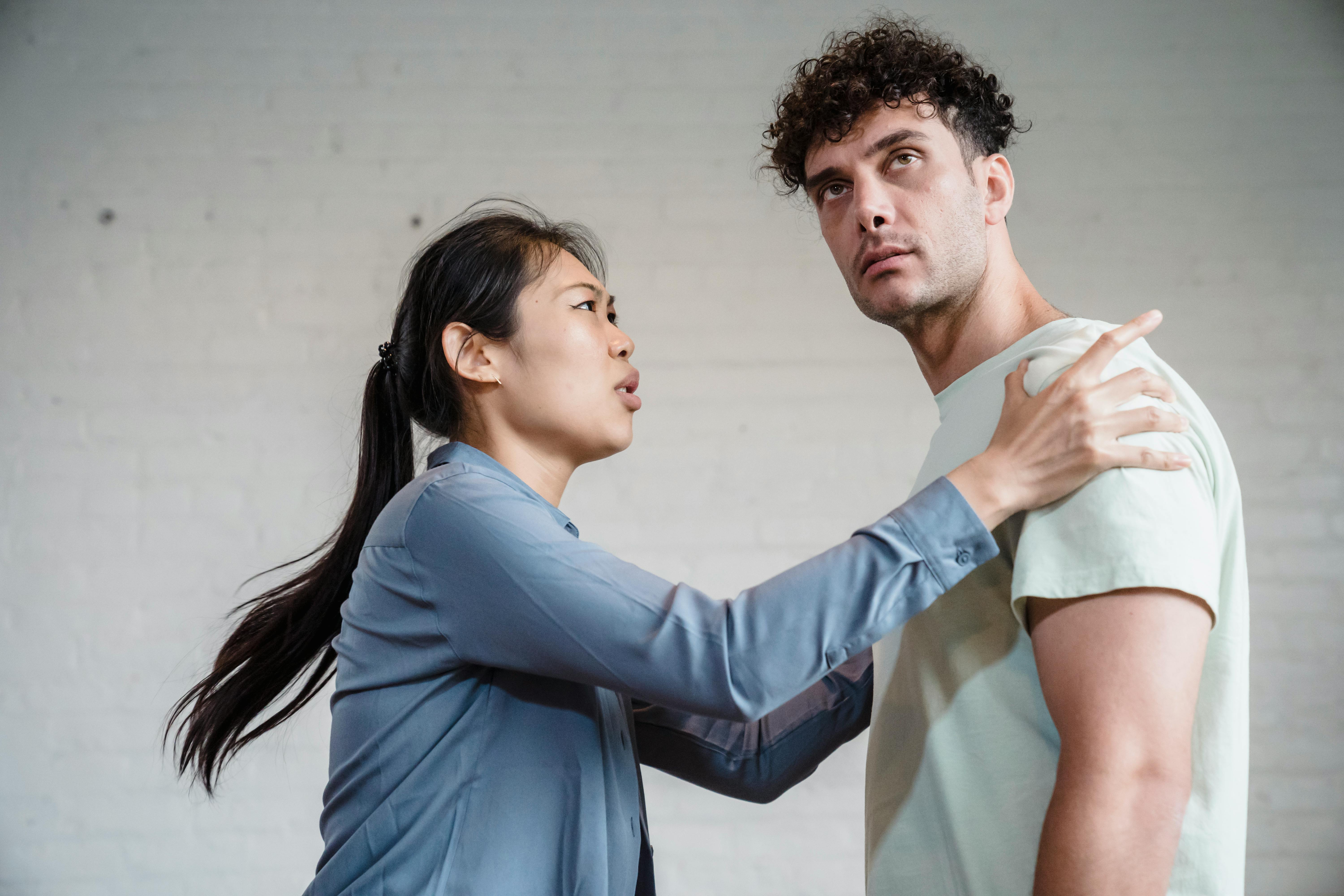 An upset woman holding the man's shoulders | Source: Pexels