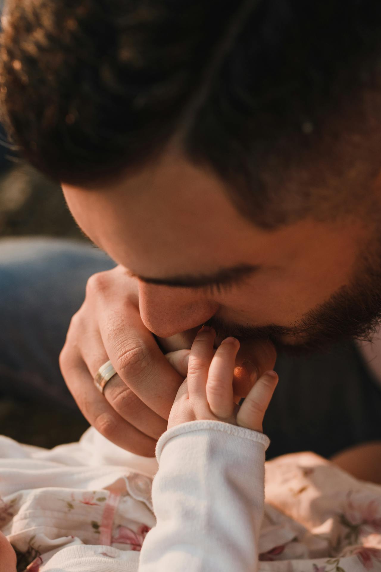 A man kissing his baby on the hand | Source: Pexels