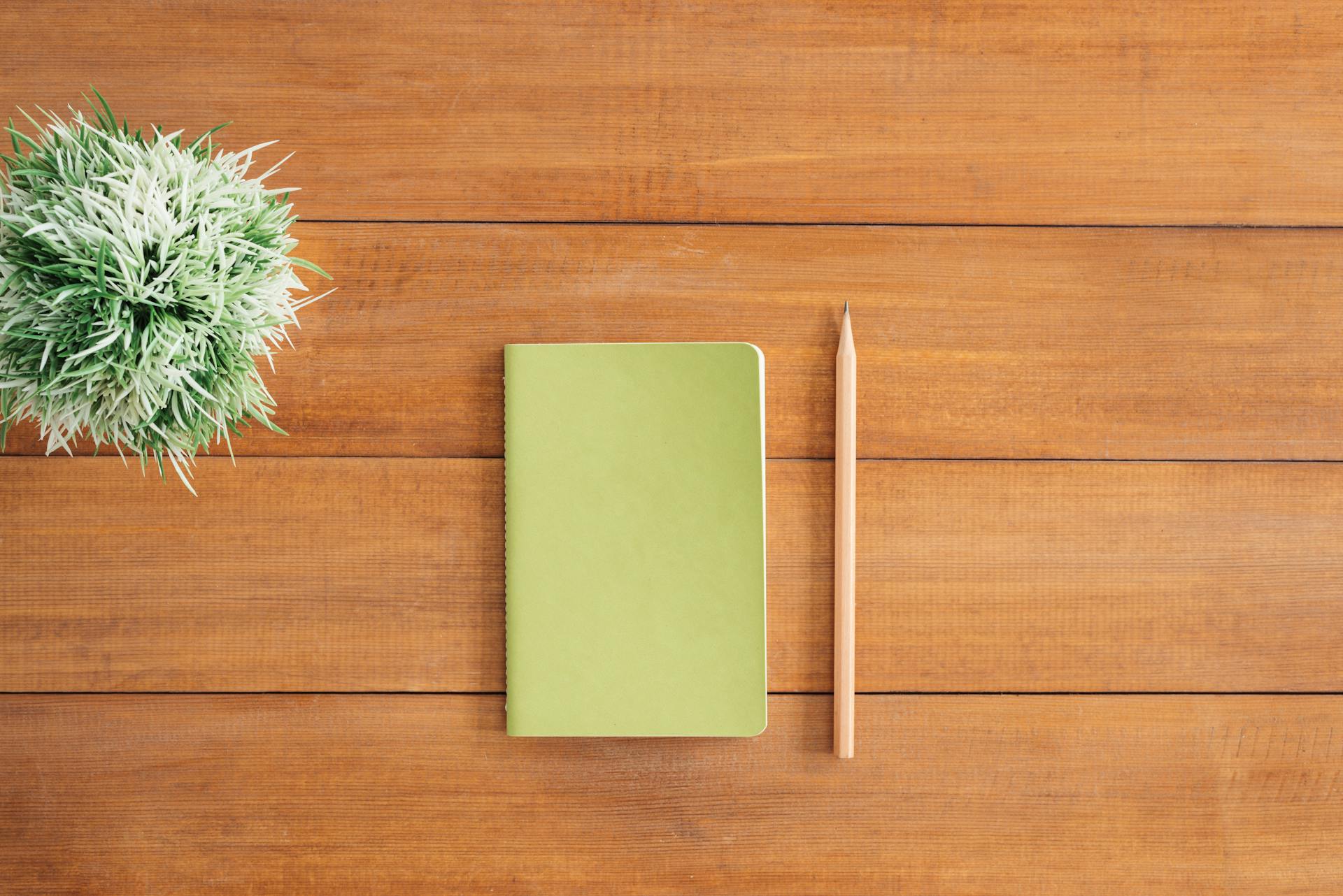 A notebook and pencil on a table | Source: Pexels