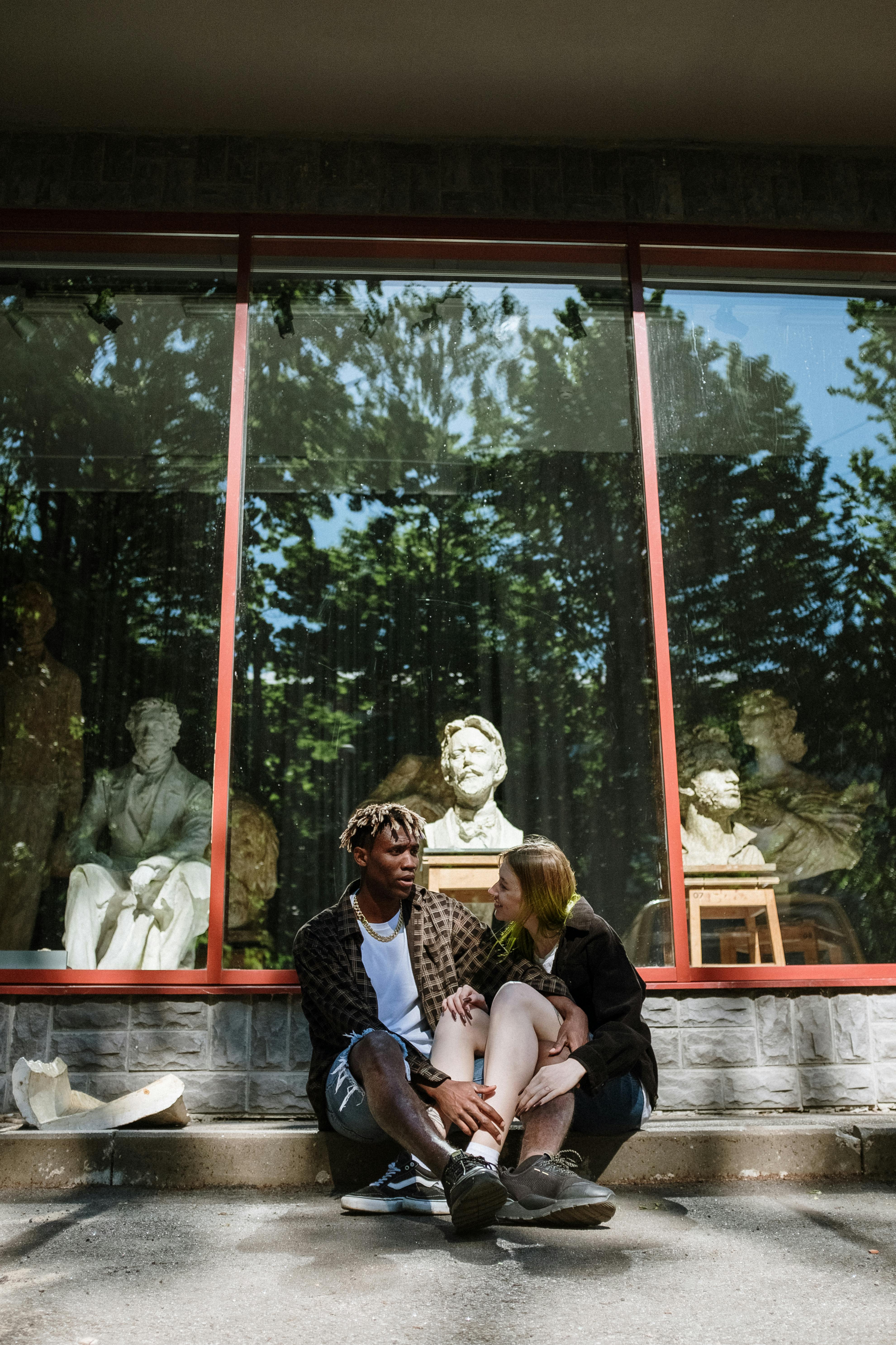 A man talks as the woman listens while sitting outdoors | Source: Pexels