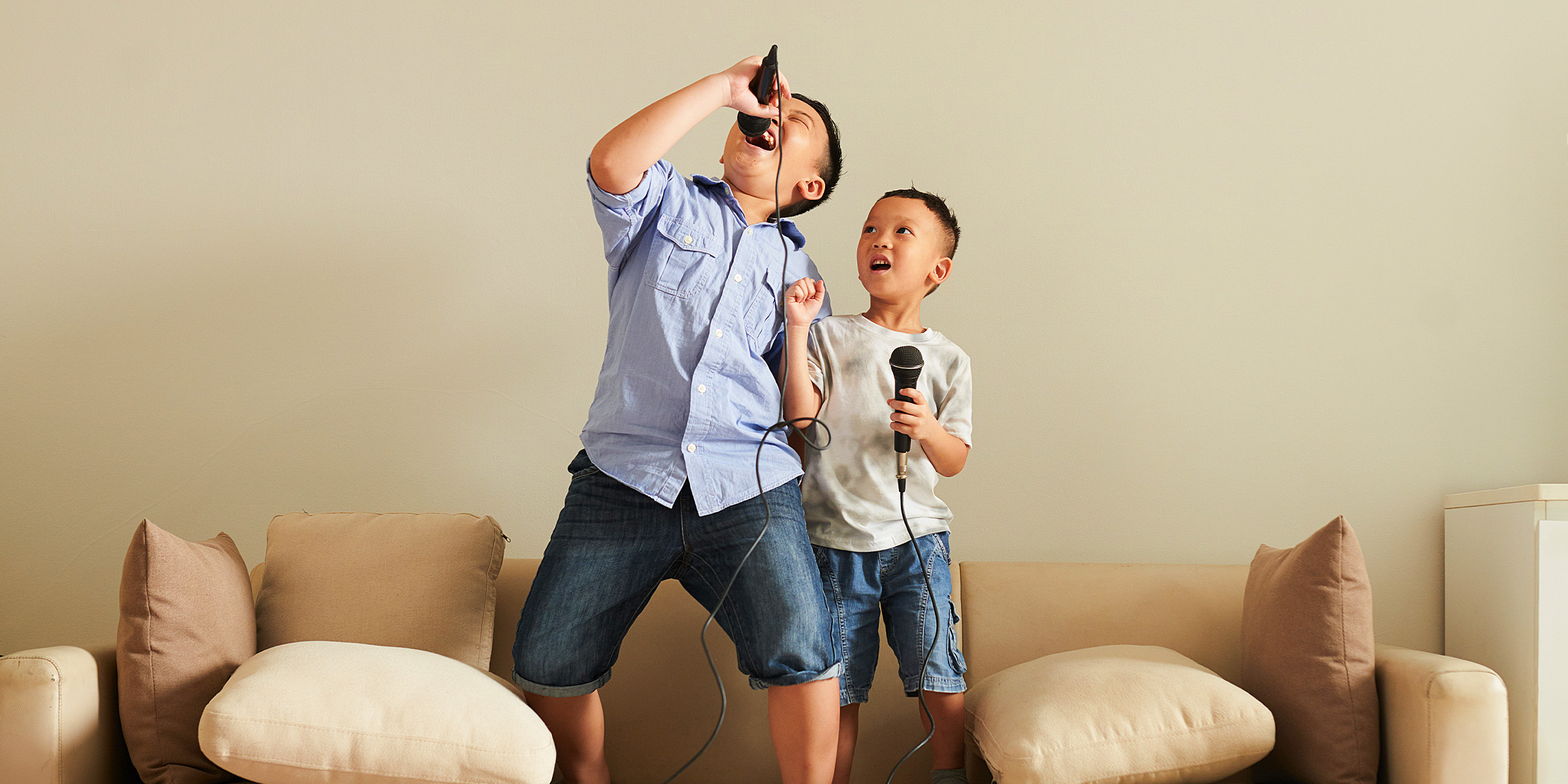 Two young boys holding microphones and chilling together | Source: Shutterstock